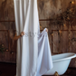 Rustic style a bathroom with a bathtub and a elegant shower curtain in white color.