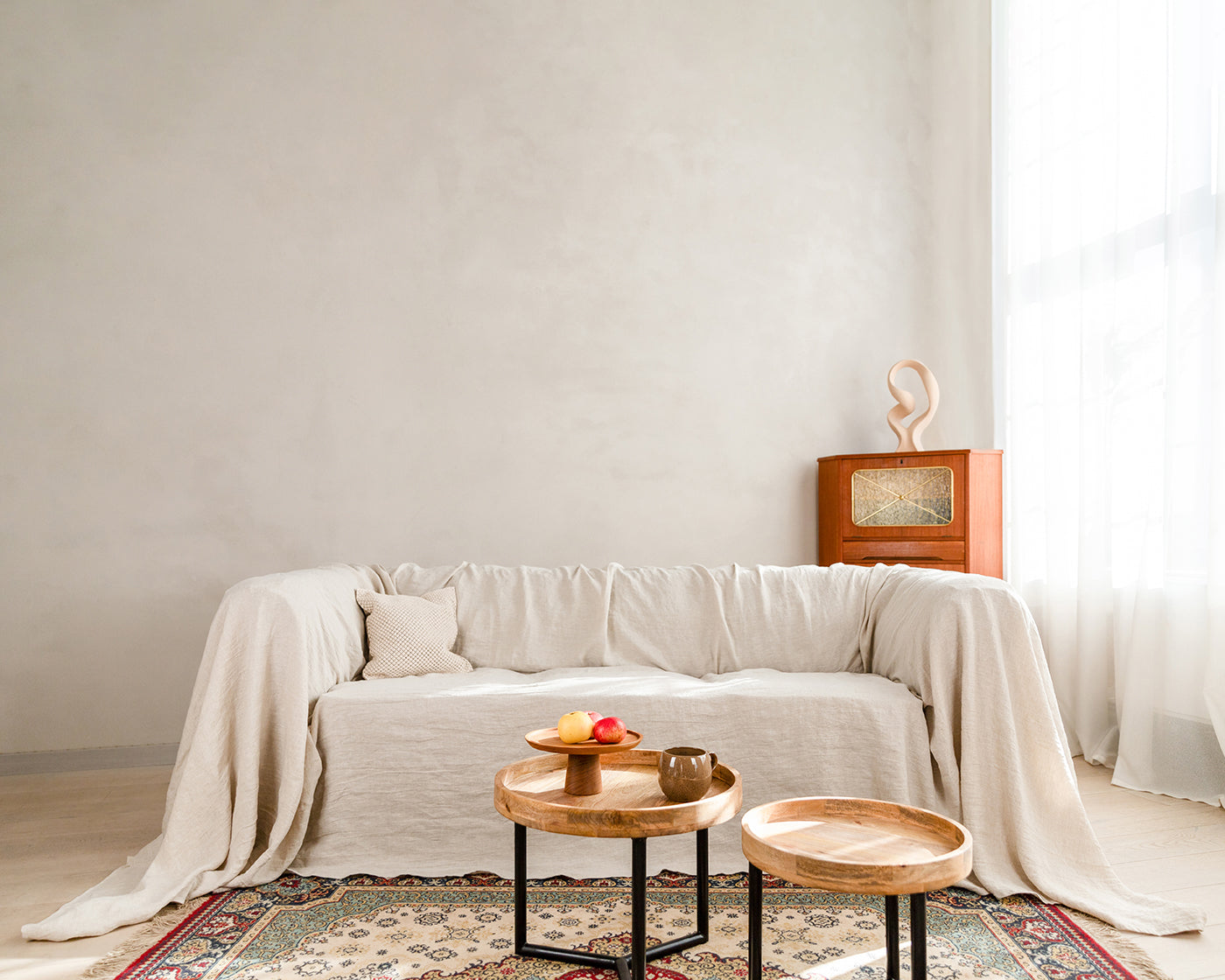 a living room with a natural light color linen couch cover couch and a coffee table