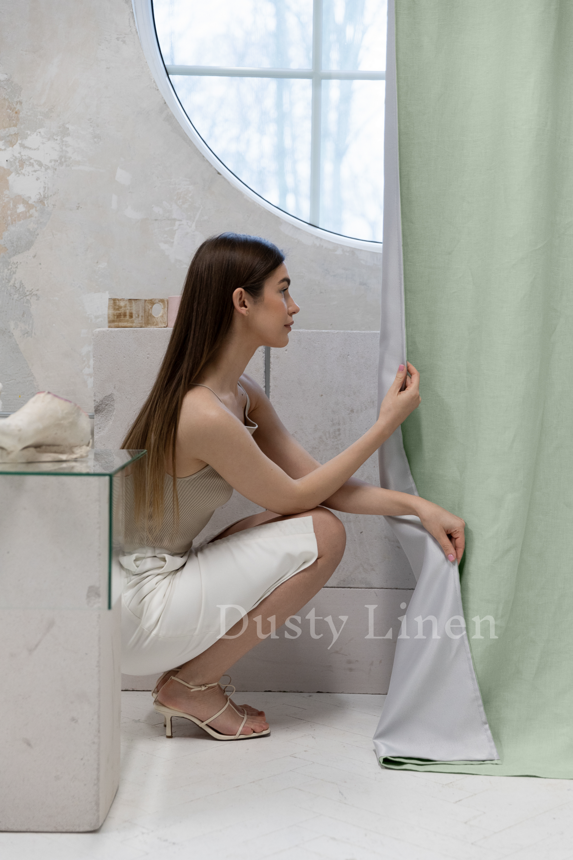 a woman sitting on the floor next to a window