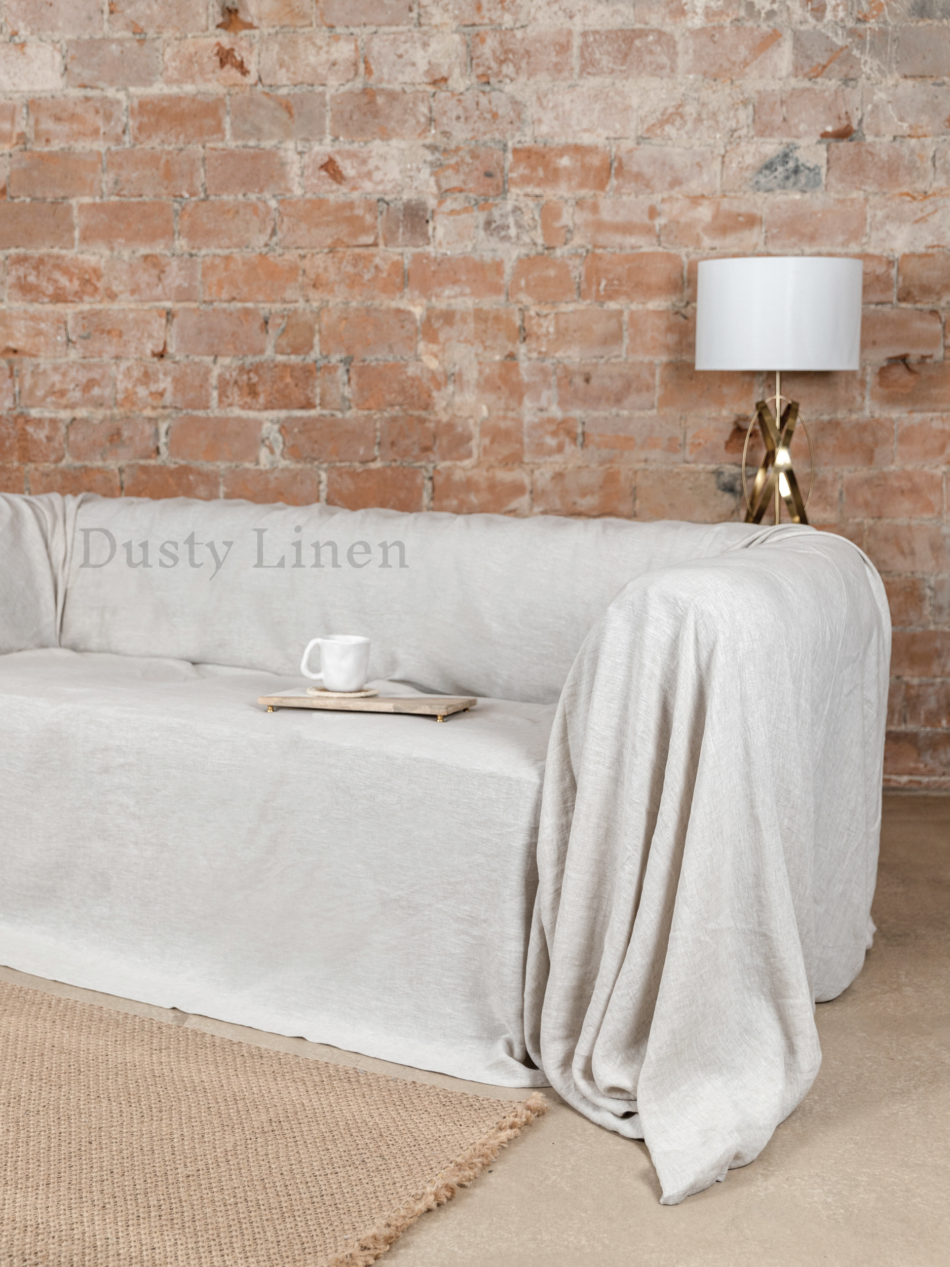 a couch covered in a blanket next to a lamp