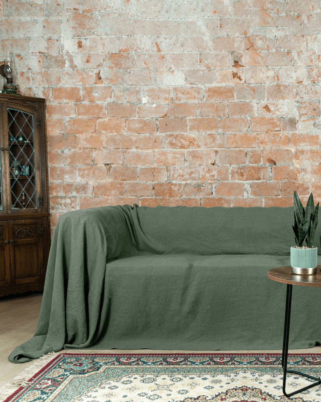 a living room with a couch covered in a green cover