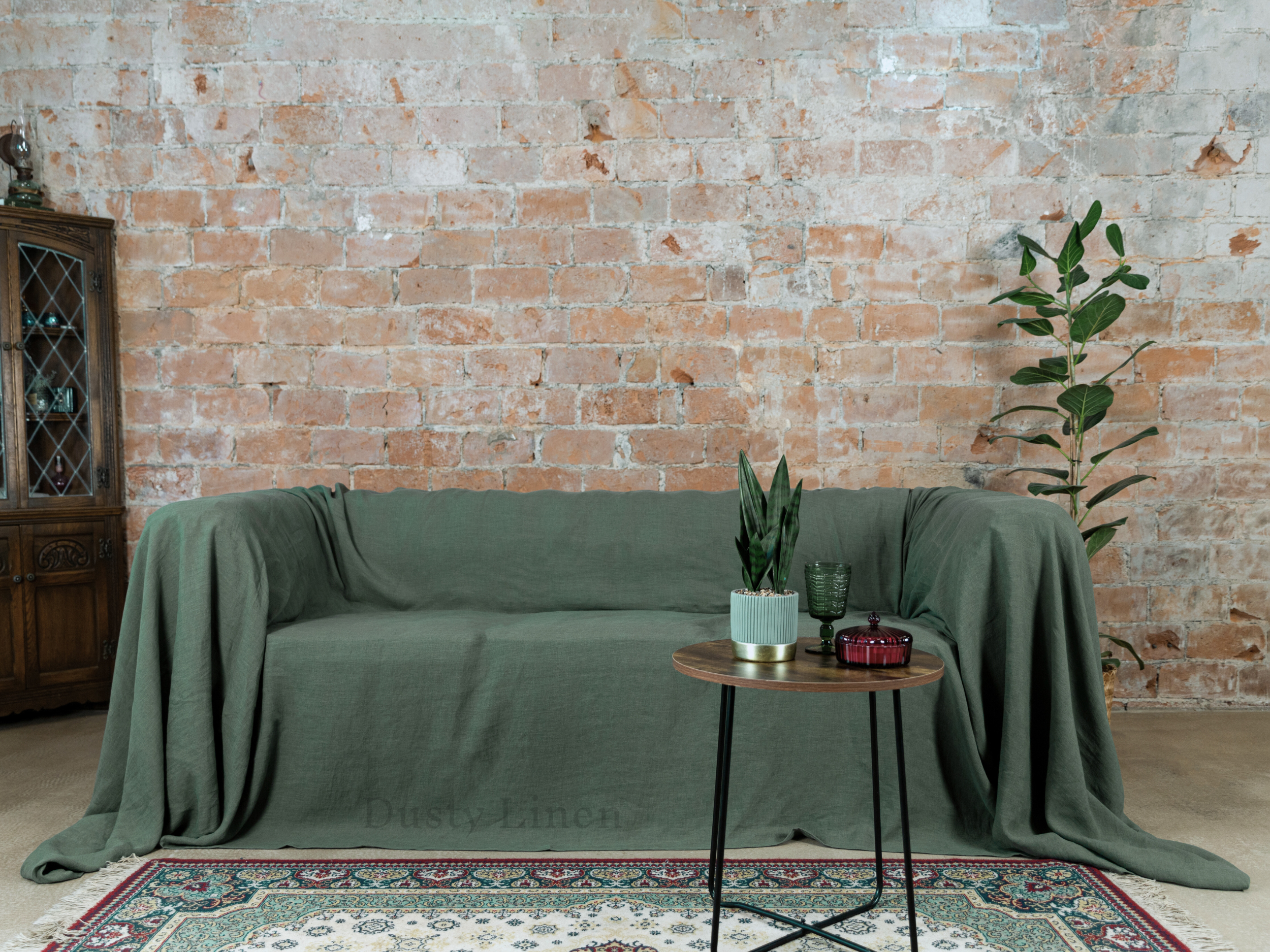 a living room with a couch covered in a green cover