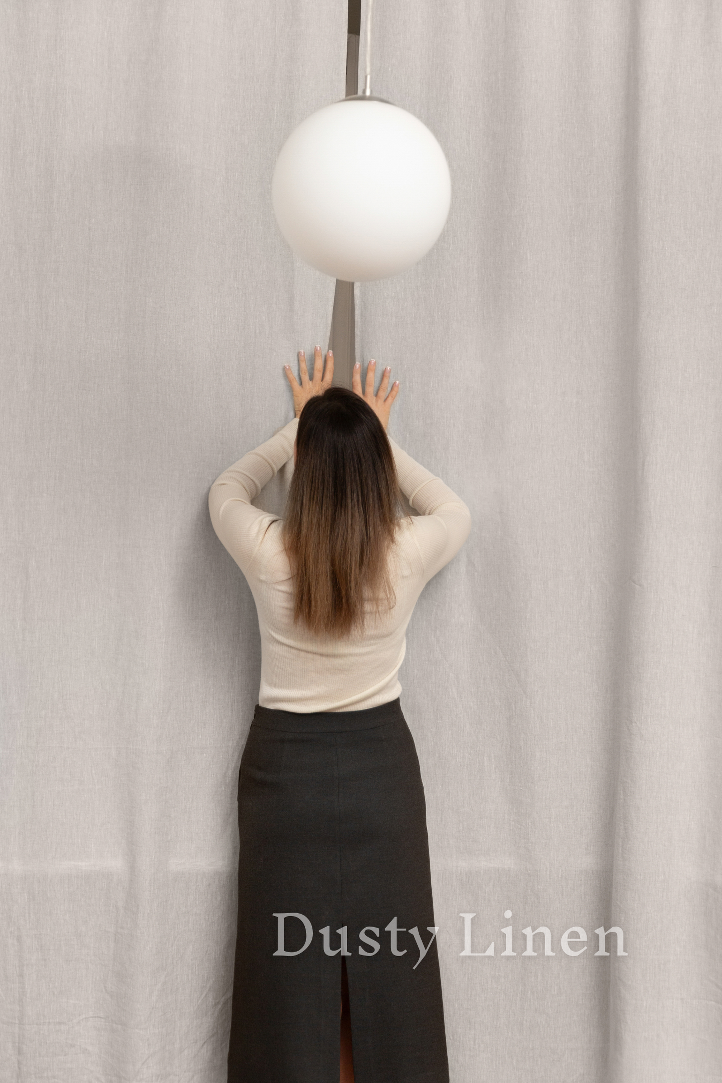 a woman in a skirt is holding a lamp above her head