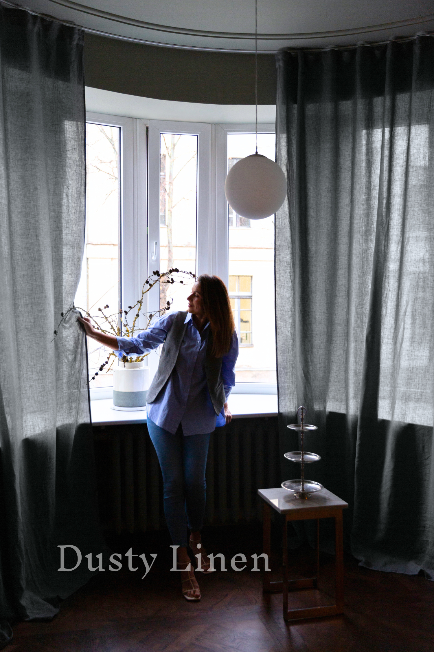 a woman standing in front of a window talking on a cell phone