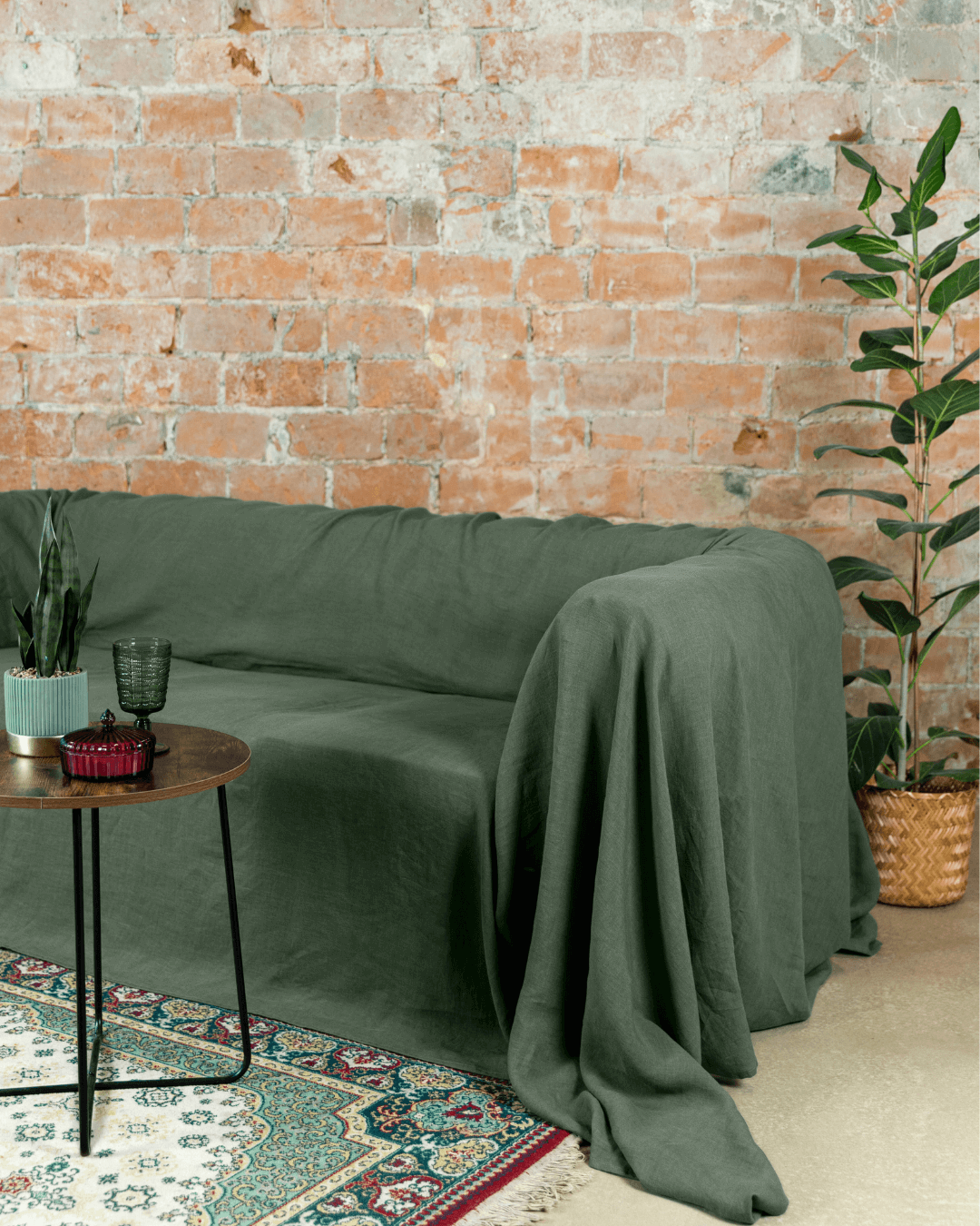a living room with a brick wall and a green couch