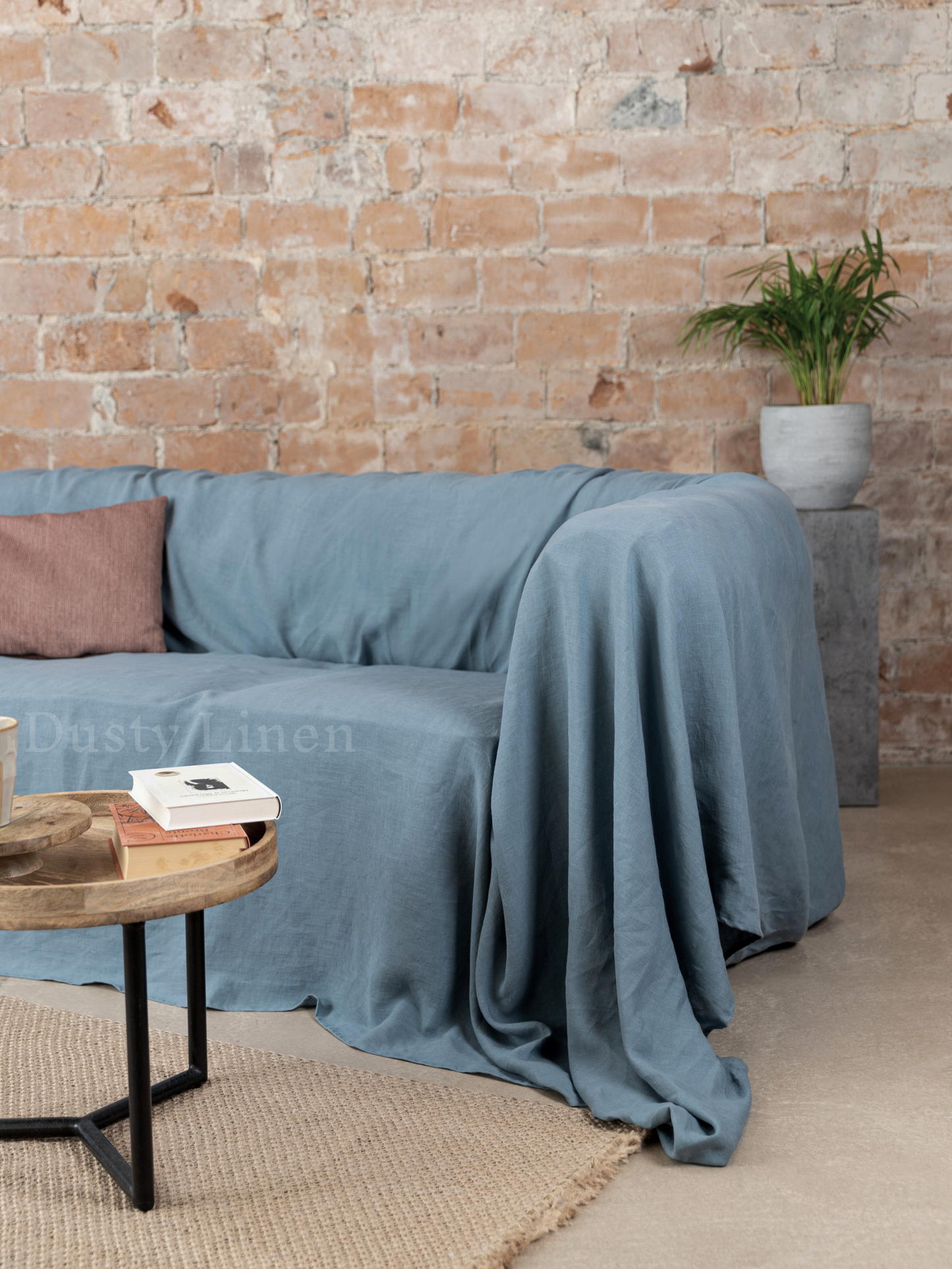 a living room with a couch, coffee table and a brick wall