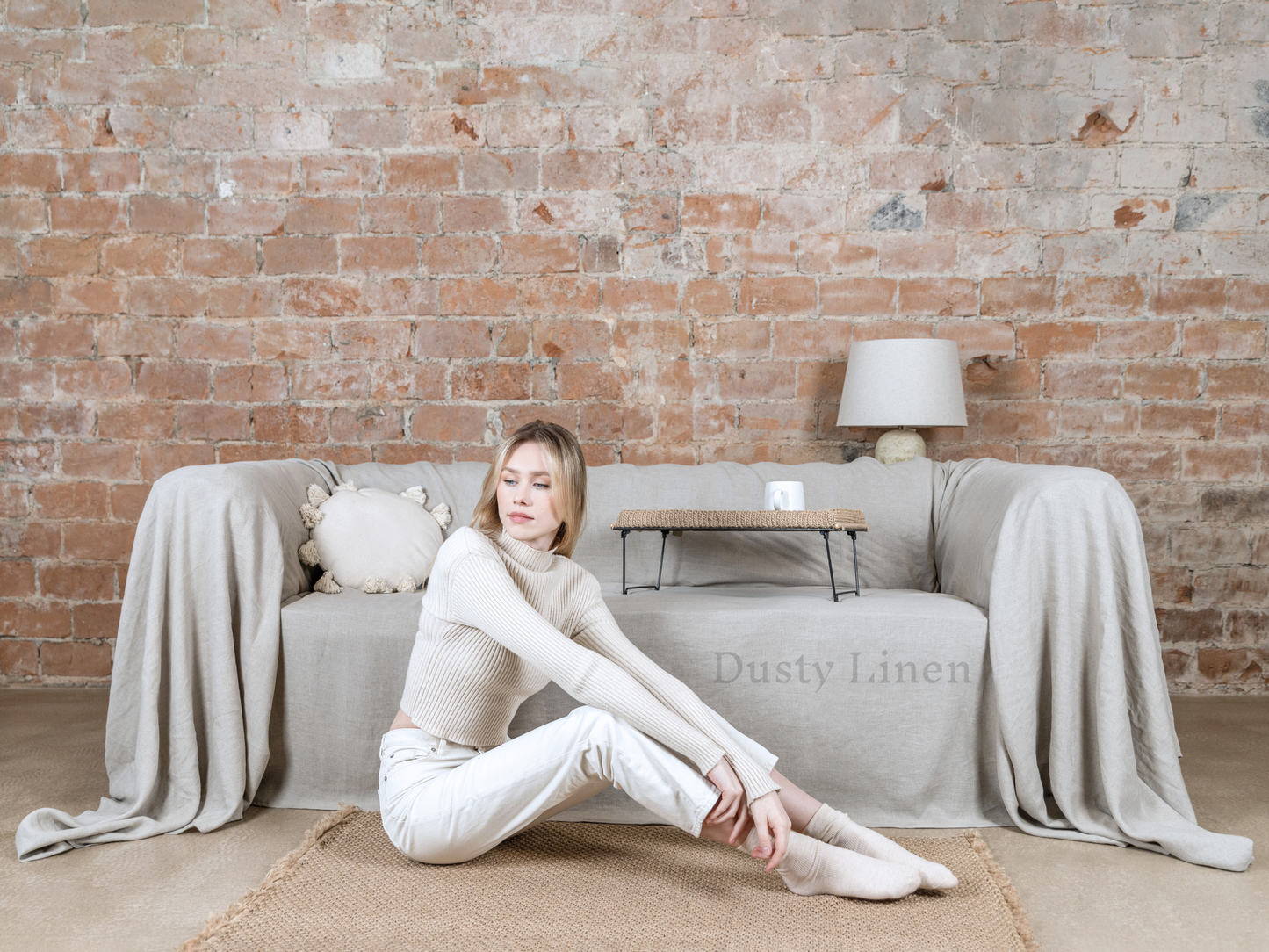 a woman sitting on a rug in front of a couch