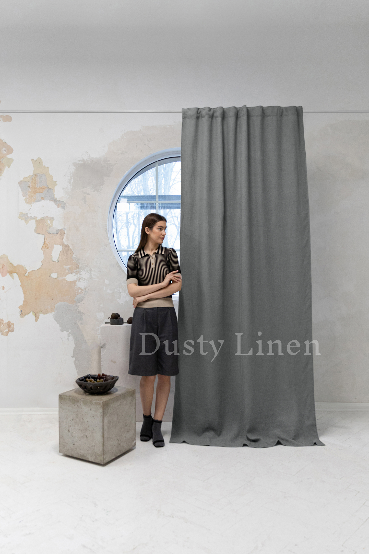 a woman standing in front of a curtain