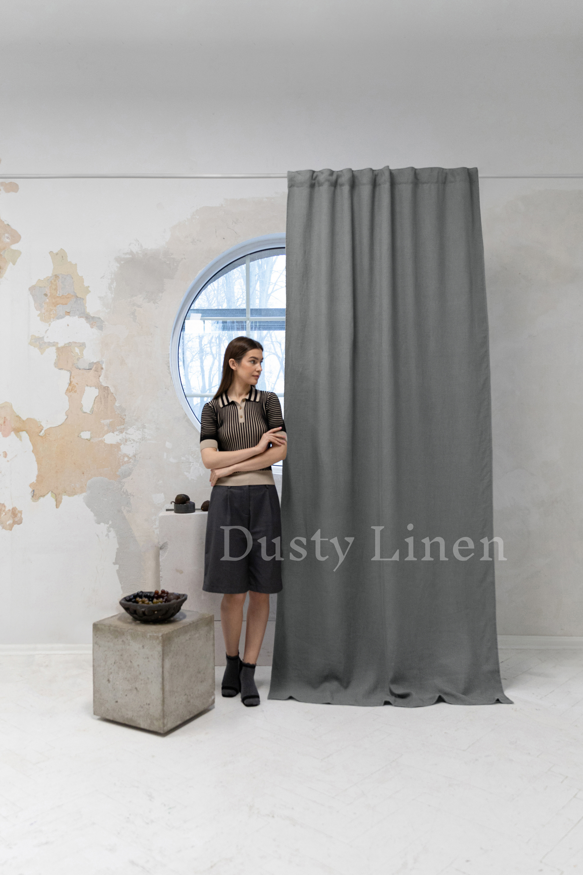 a woman standing in front of a curtain