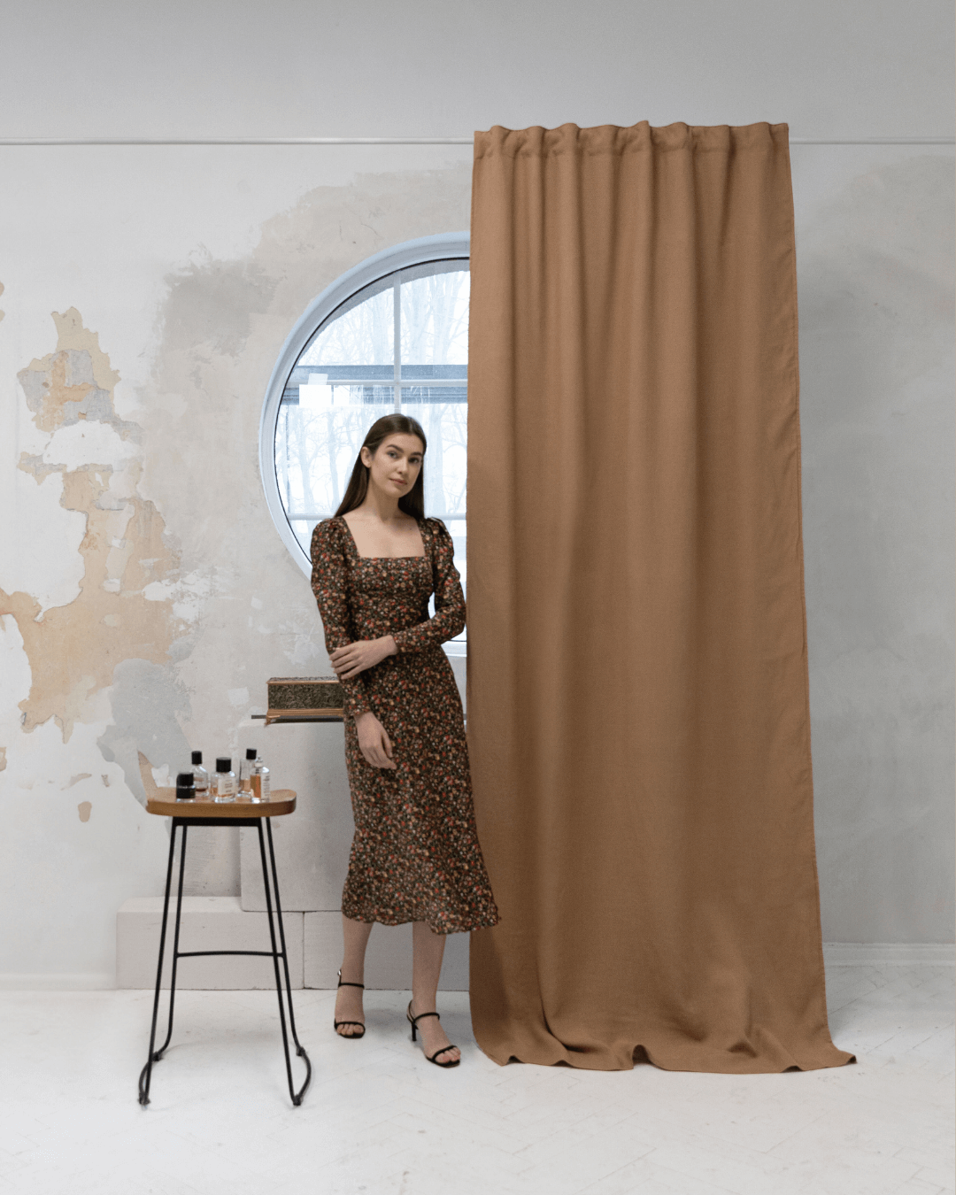 Woman in front of camel brown linen blackout curtain, full length view