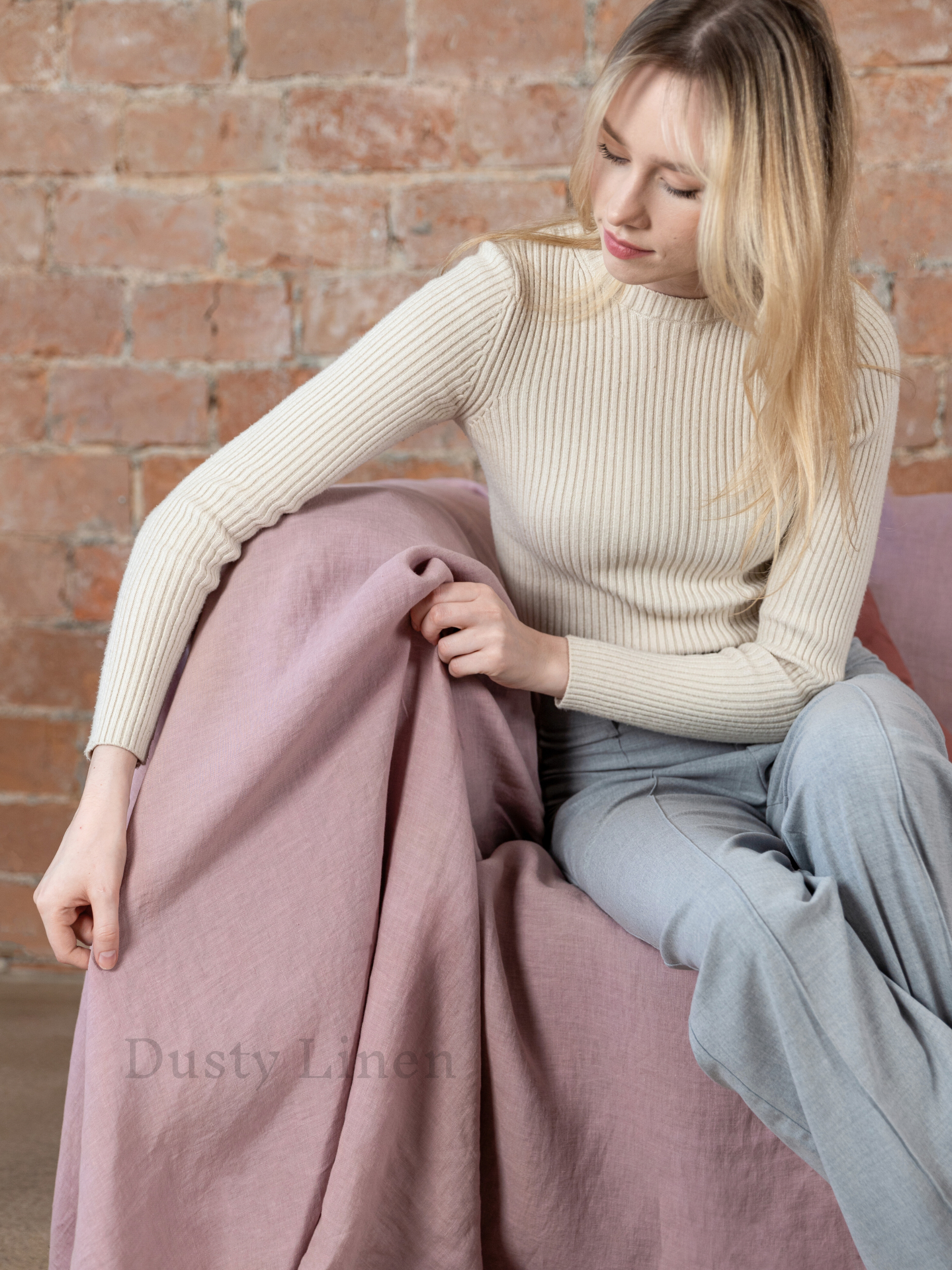 a woman is sitting on a pink chair