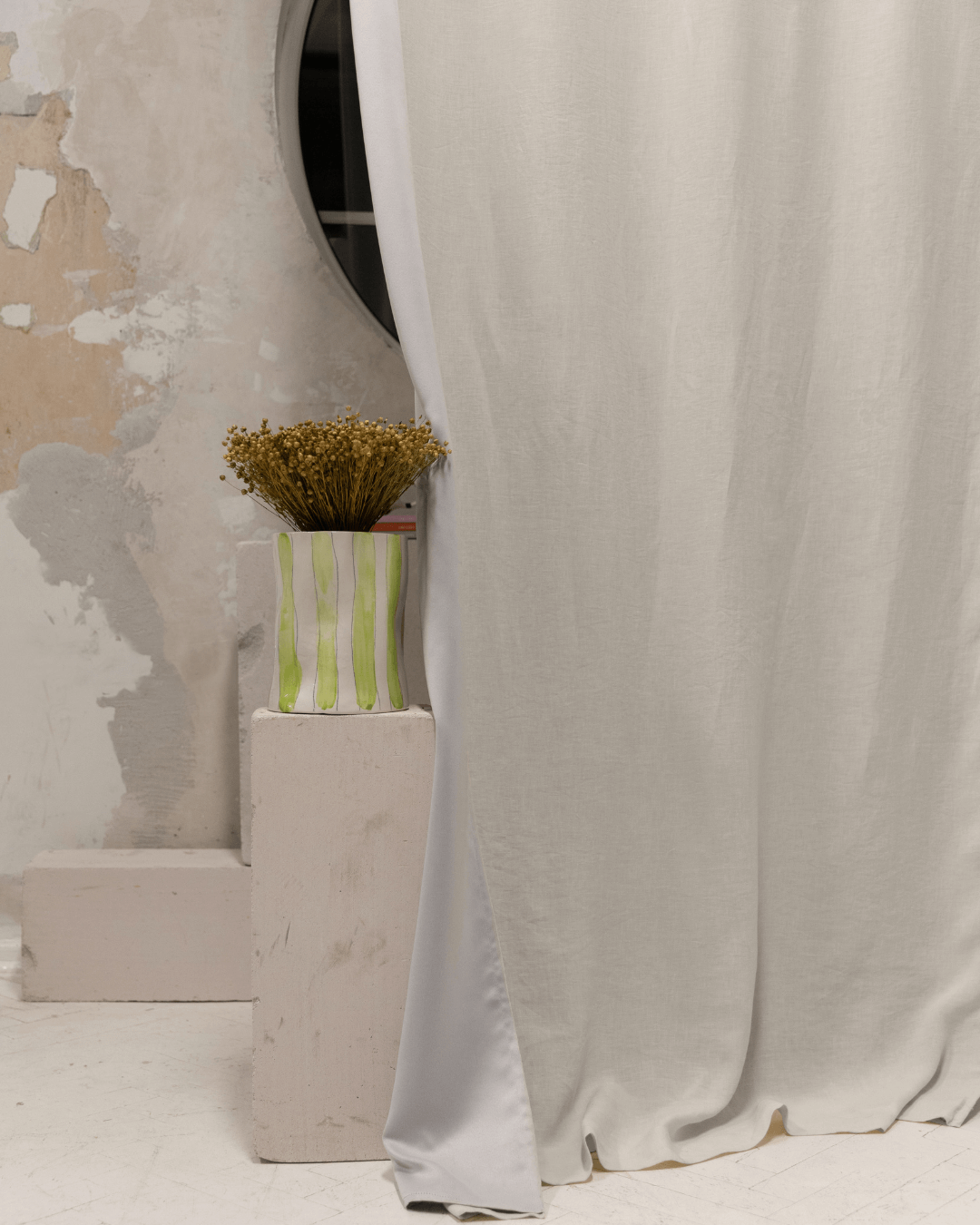 Cream linen blackout curtains with floral vase, styled interior detail