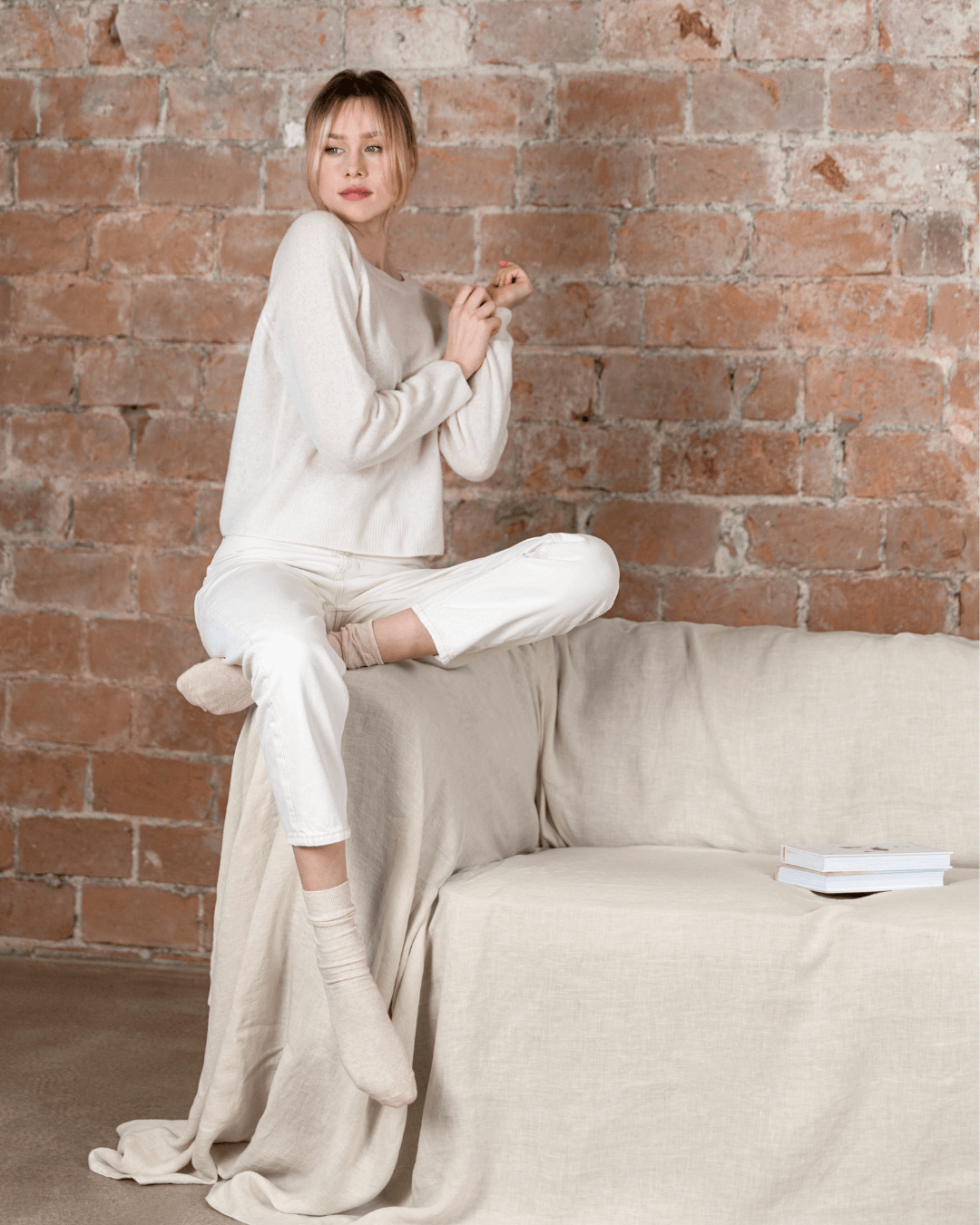 Woman relaxing on sofa with cream loose linen couch cover