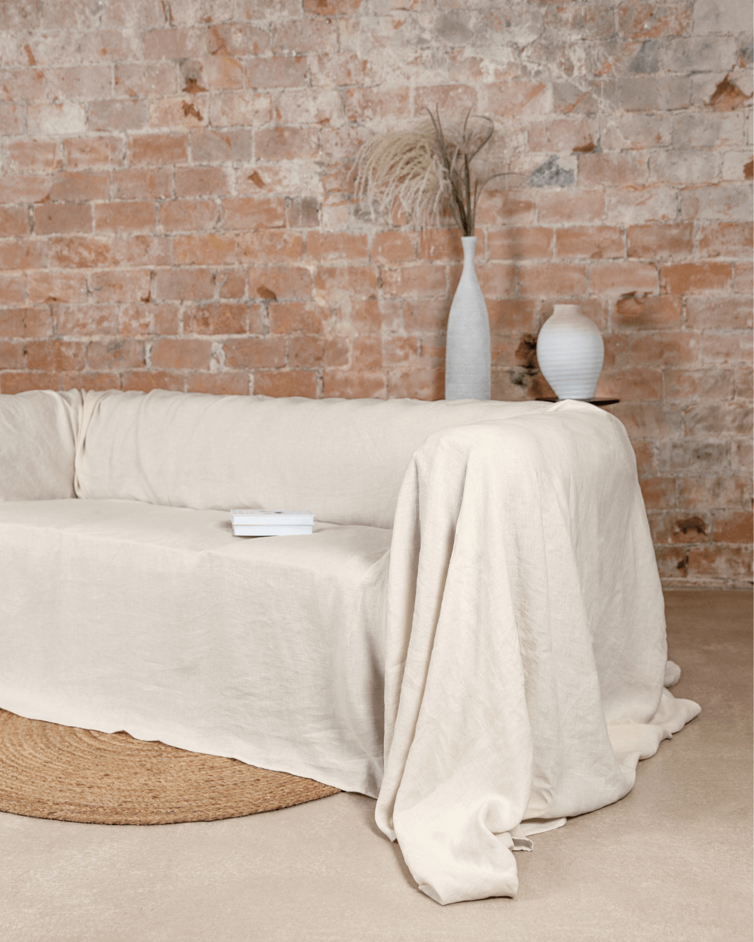 Cream loose linen couch cover draped on sofa in living room