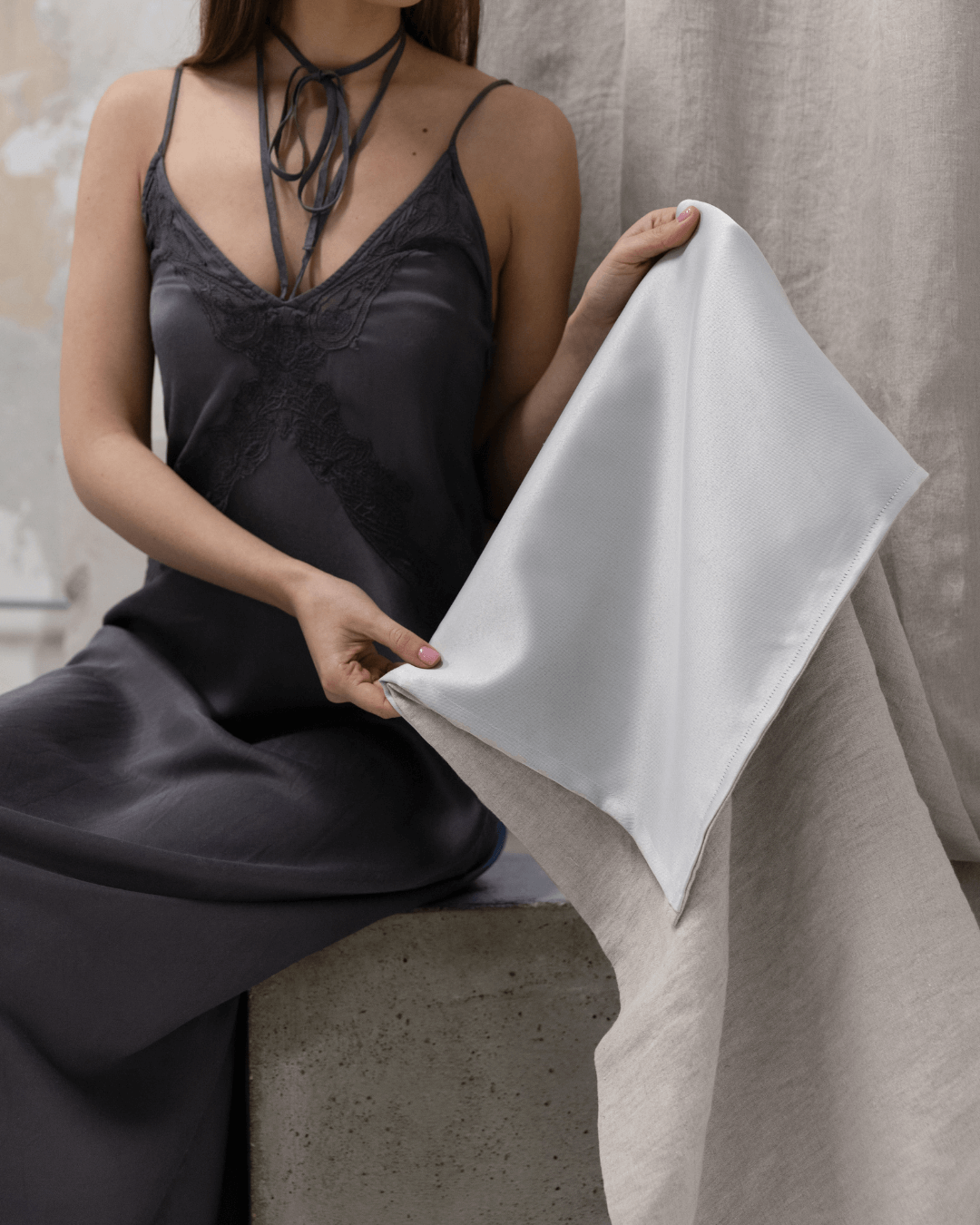 Woman holding natural light linen blackout curtain, showing fabric weight