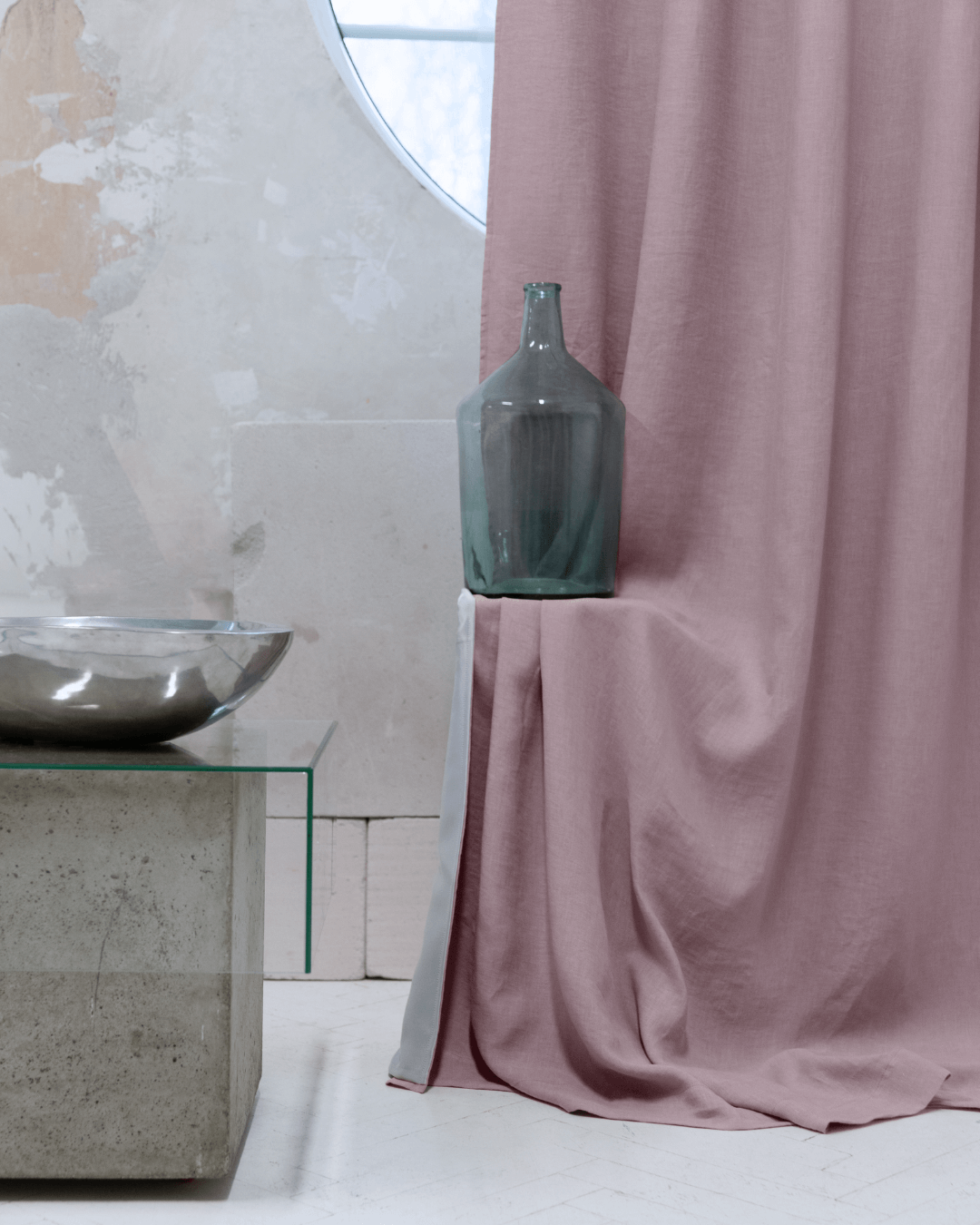 a vase sitting on a table next to a curtain