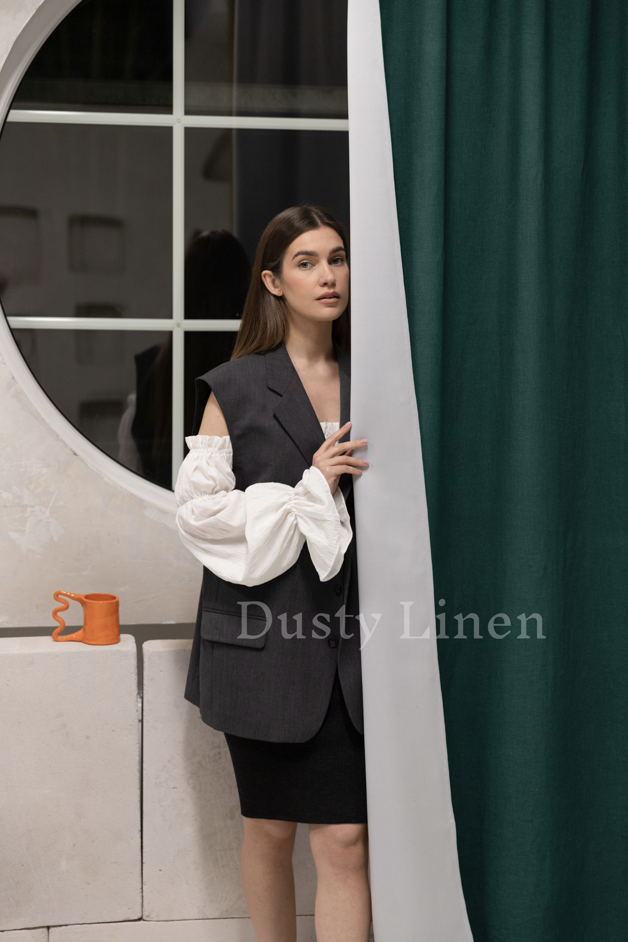 a woman standing behind a curtain in front of a window