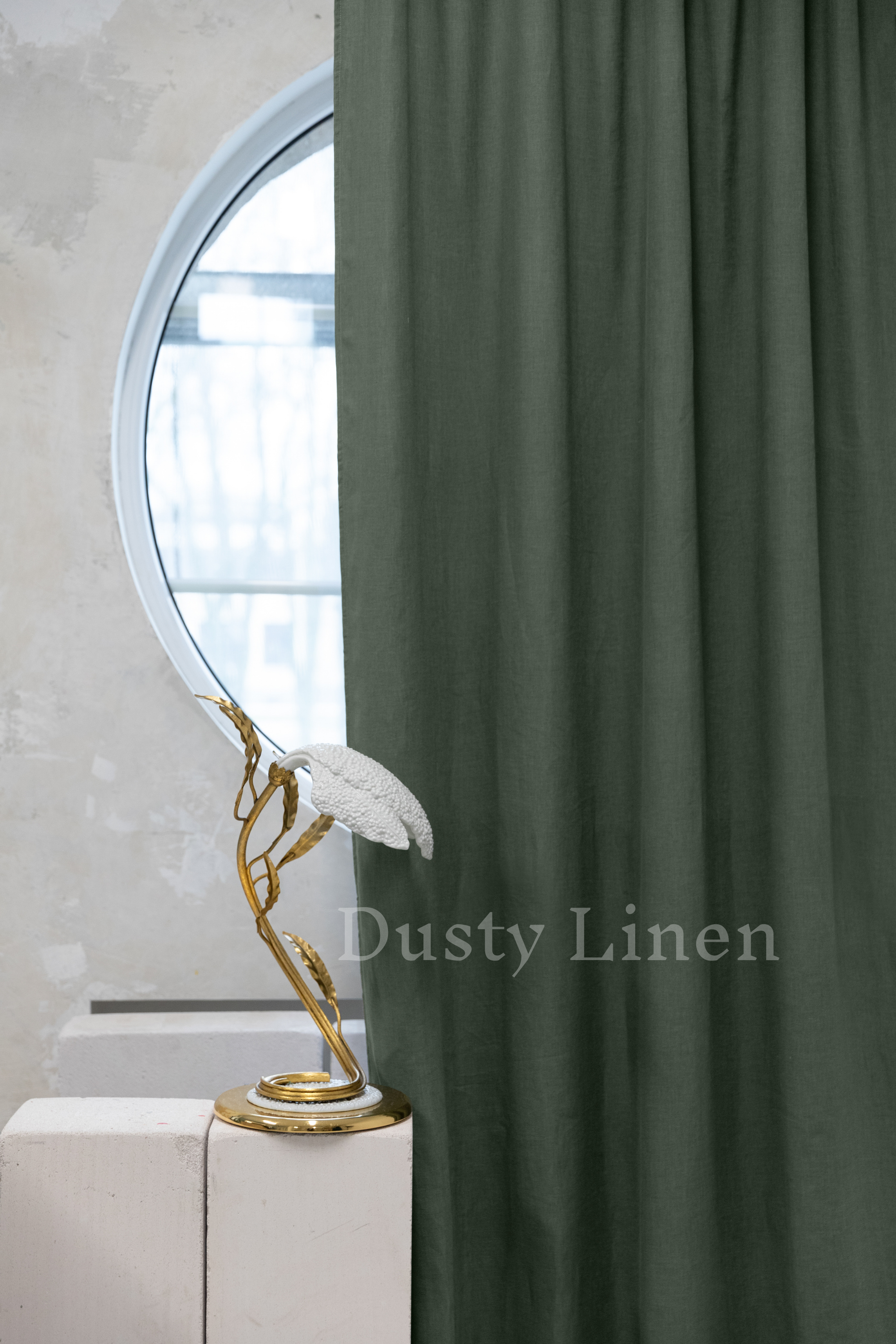 a statue of a bird on a pedestal in front of a curtain