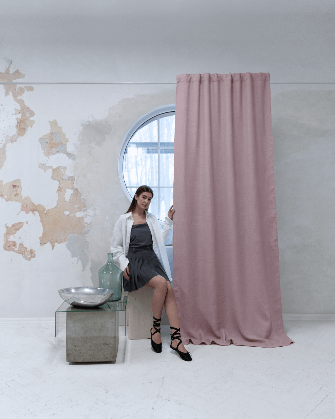 Woman on stool beside dusty rose linen blackout curtains at window