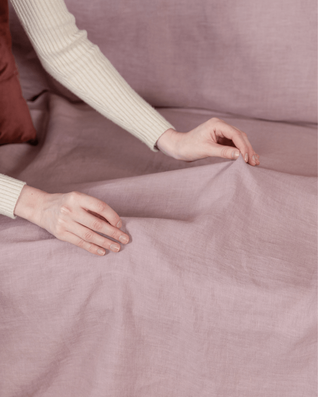 Woman relaxing on sofa with dusty rose linen sofa cover