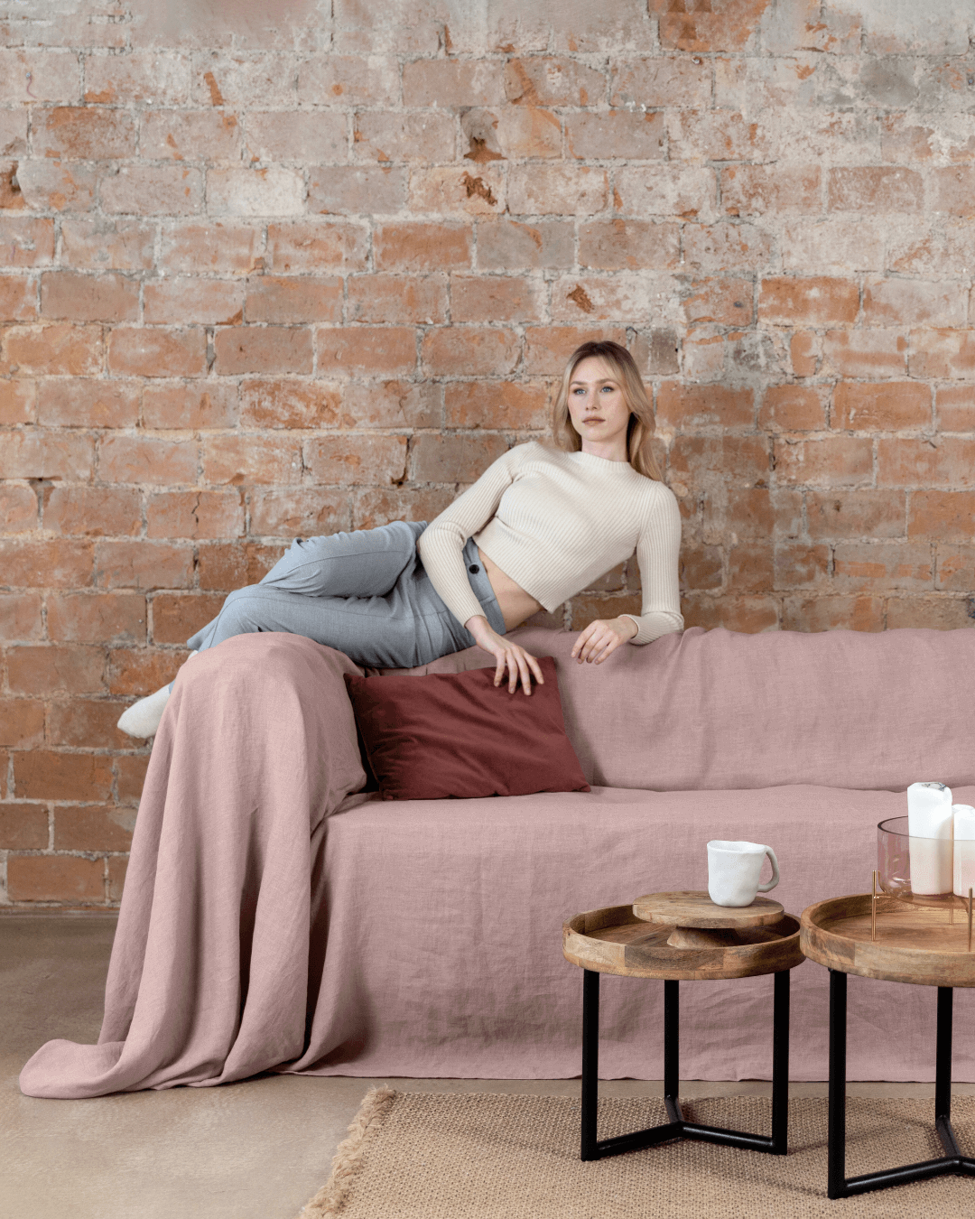 Woman on sofa with dusty rose linen couch cover, lifestyle photo