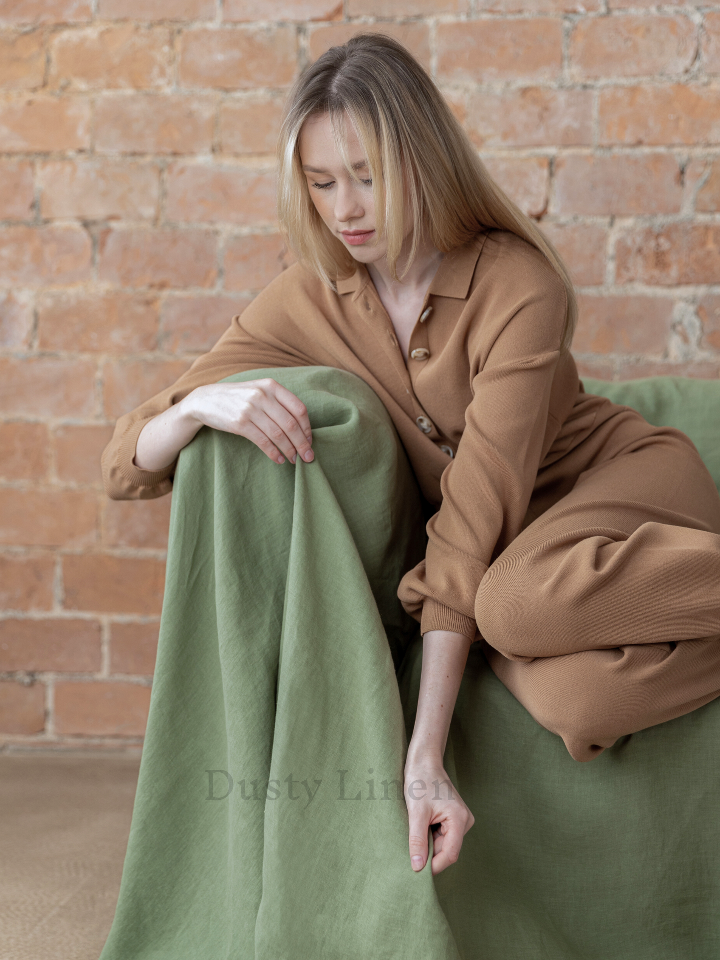 a woman is sitting on a green couch