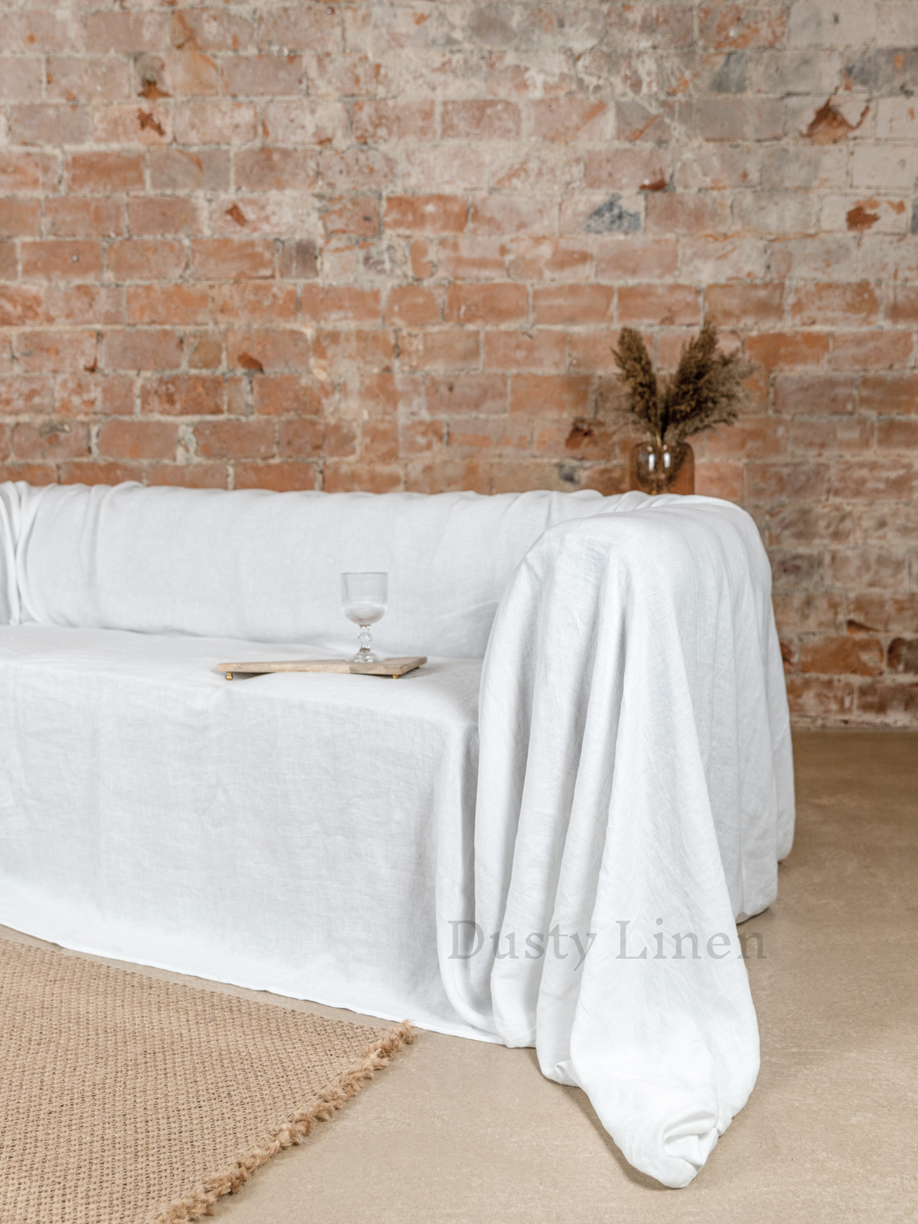 a white couch covered with a white table cloth