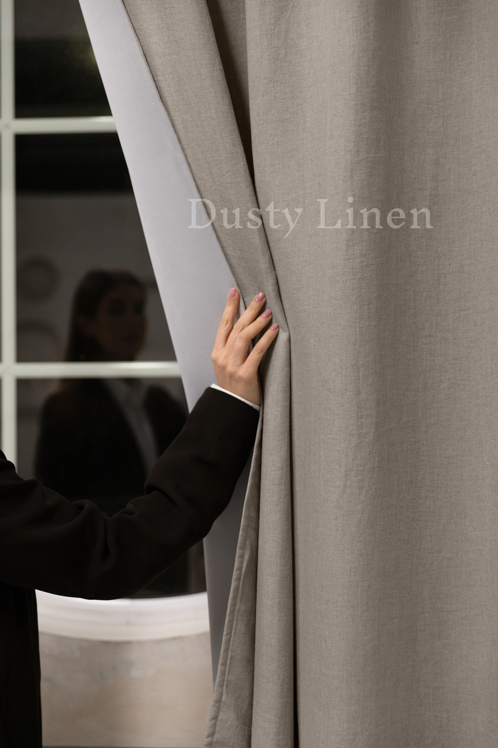 a person in a suit is opening a curtain