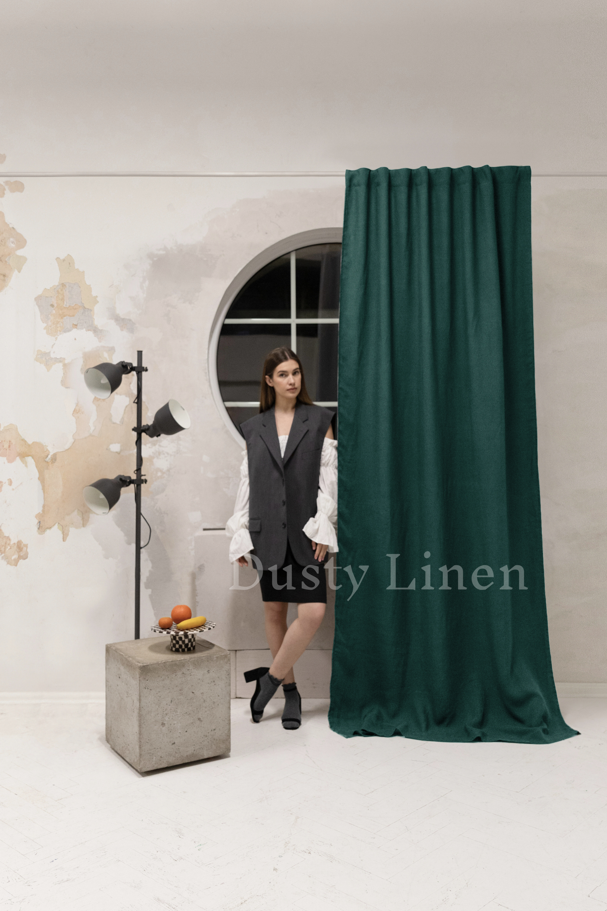 a woman standing in front of a green curtain