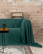 Emerald green linen sofa cover loose drape, front view, 175 g/m²