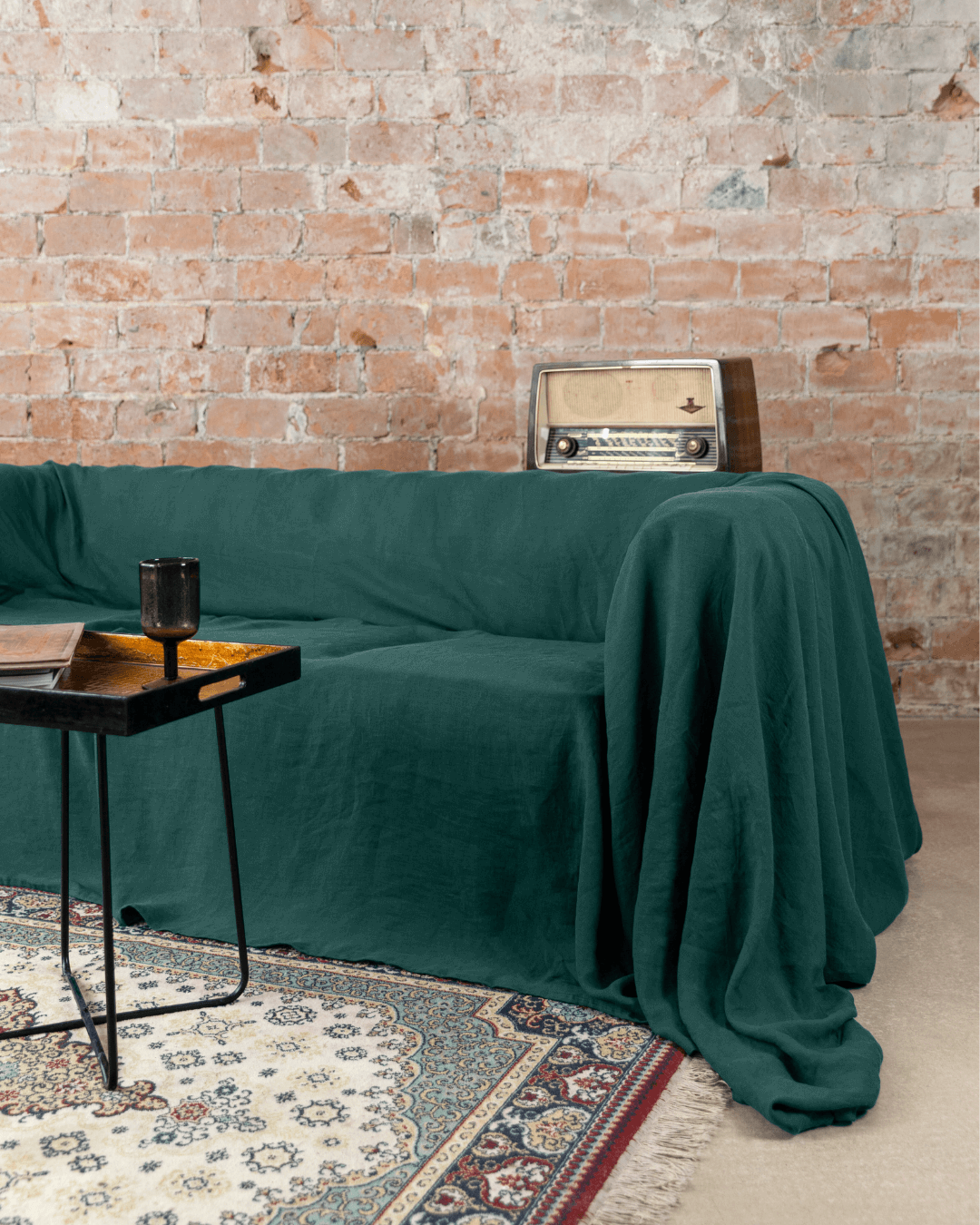 Emerald green linen sofa cover loose drape on sofa, side table