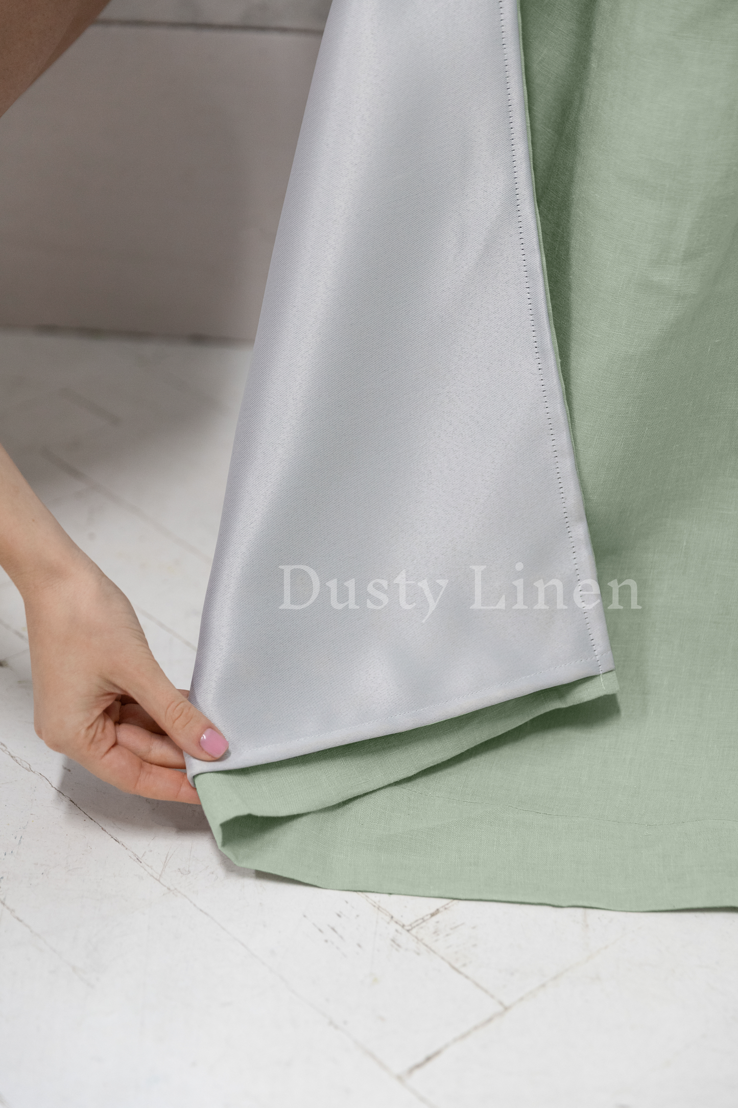 a woman is holding the side of a sheet