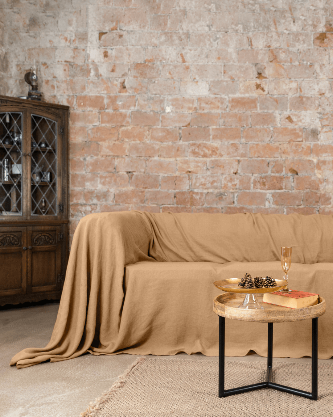 a couch covered with a blanket next to a table
