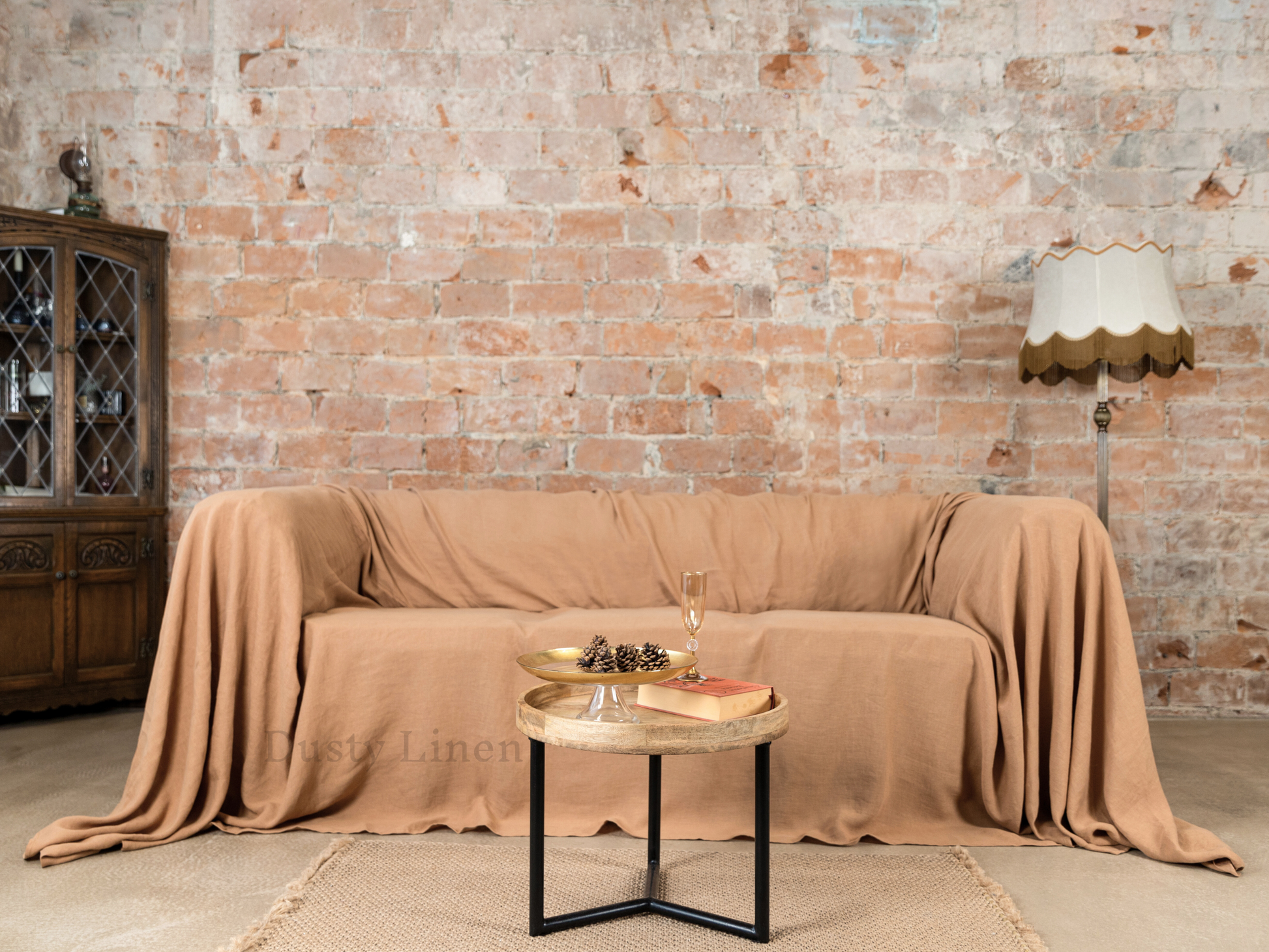 a couch covered with a blanket next to a table