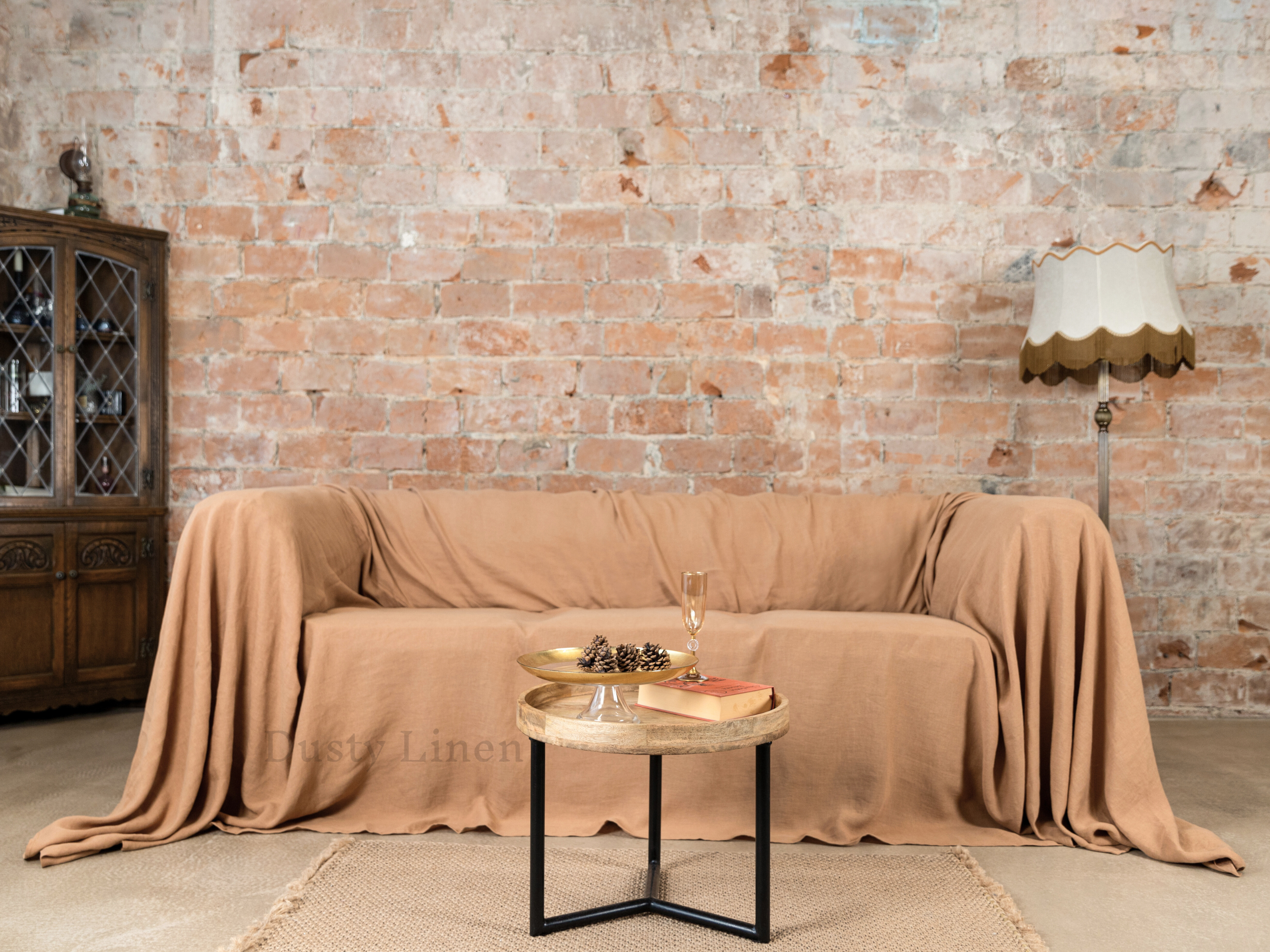 a couch covered with a blanket next to a table