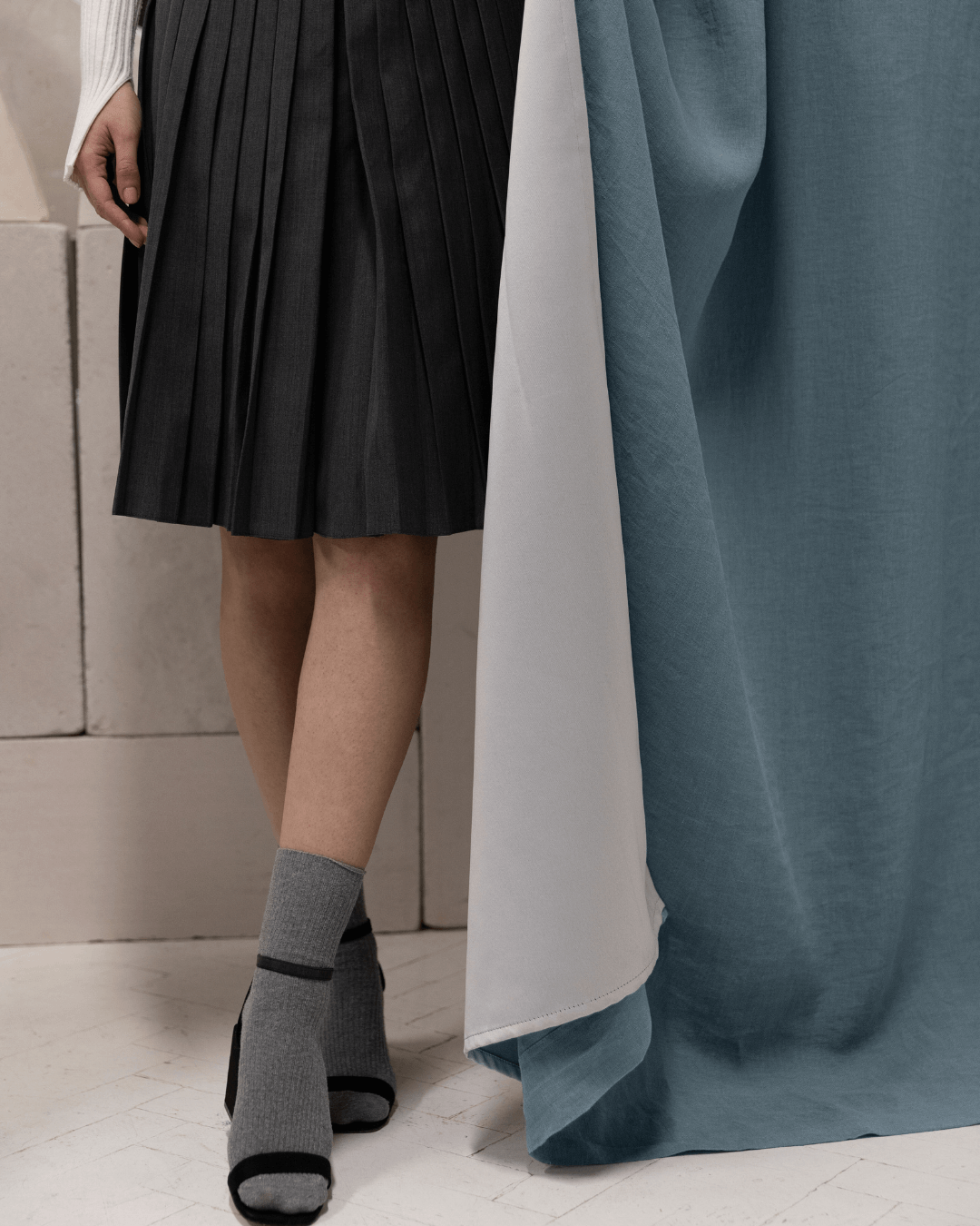 Woman beside gray blue linen blackout curtain panel, full length view