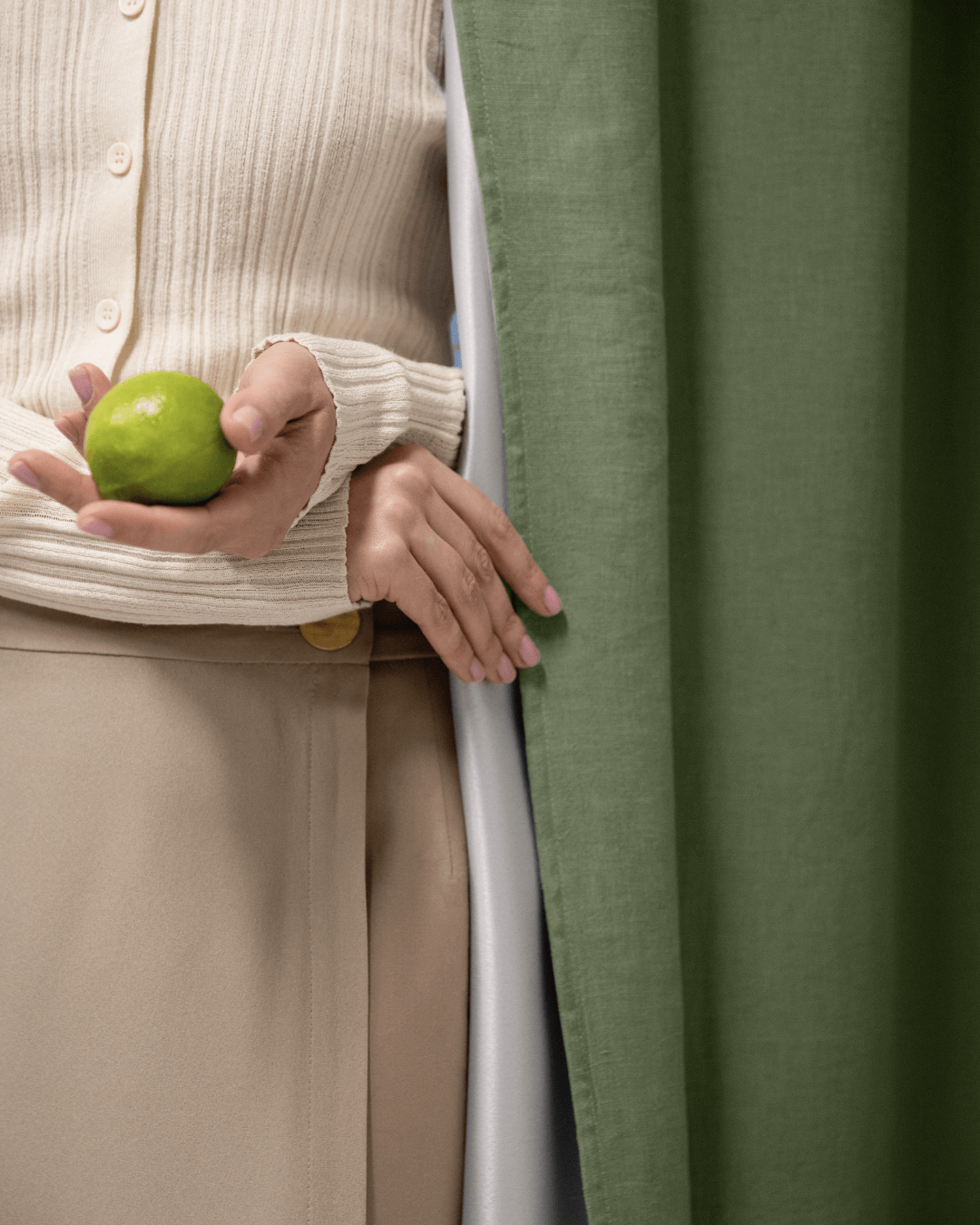 Woman behind khaki green linen blackout curtain, showing drape and privacy