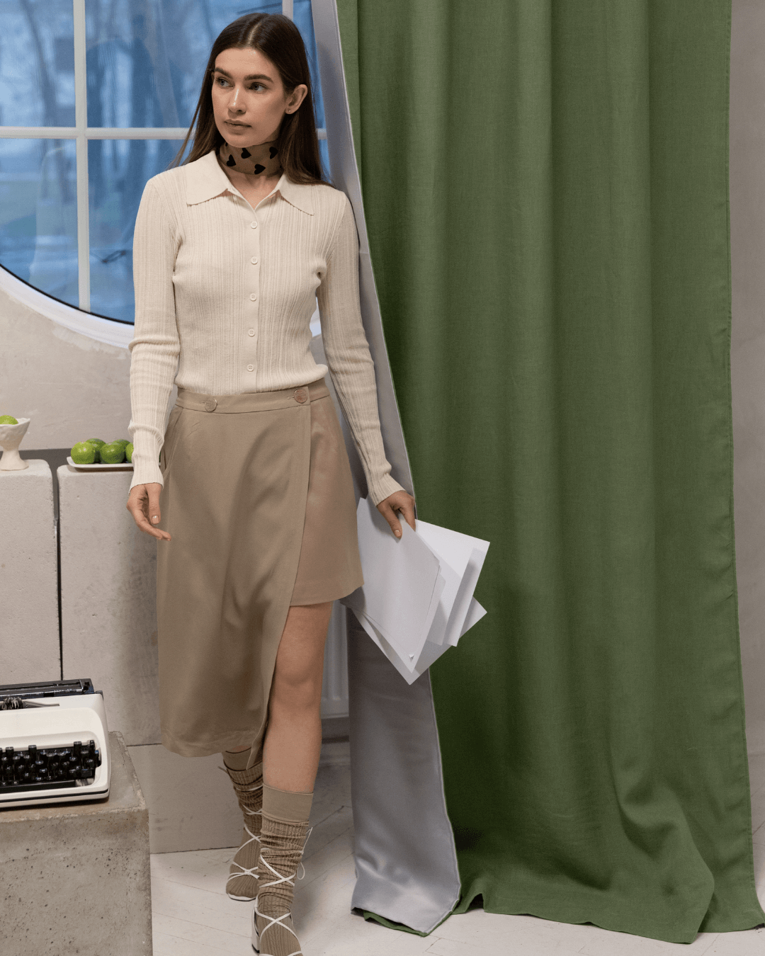 Woman in front of khaki green linen blackout curtains, lifestyle photo
