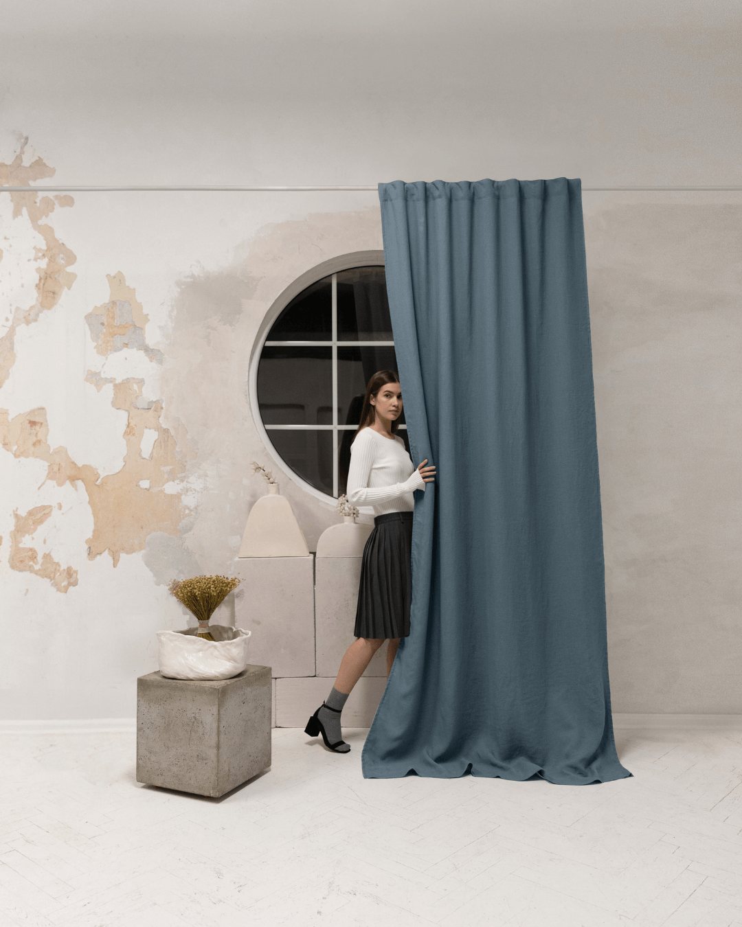 Woman behind gray blue linen blackout curtain, showing privacy level