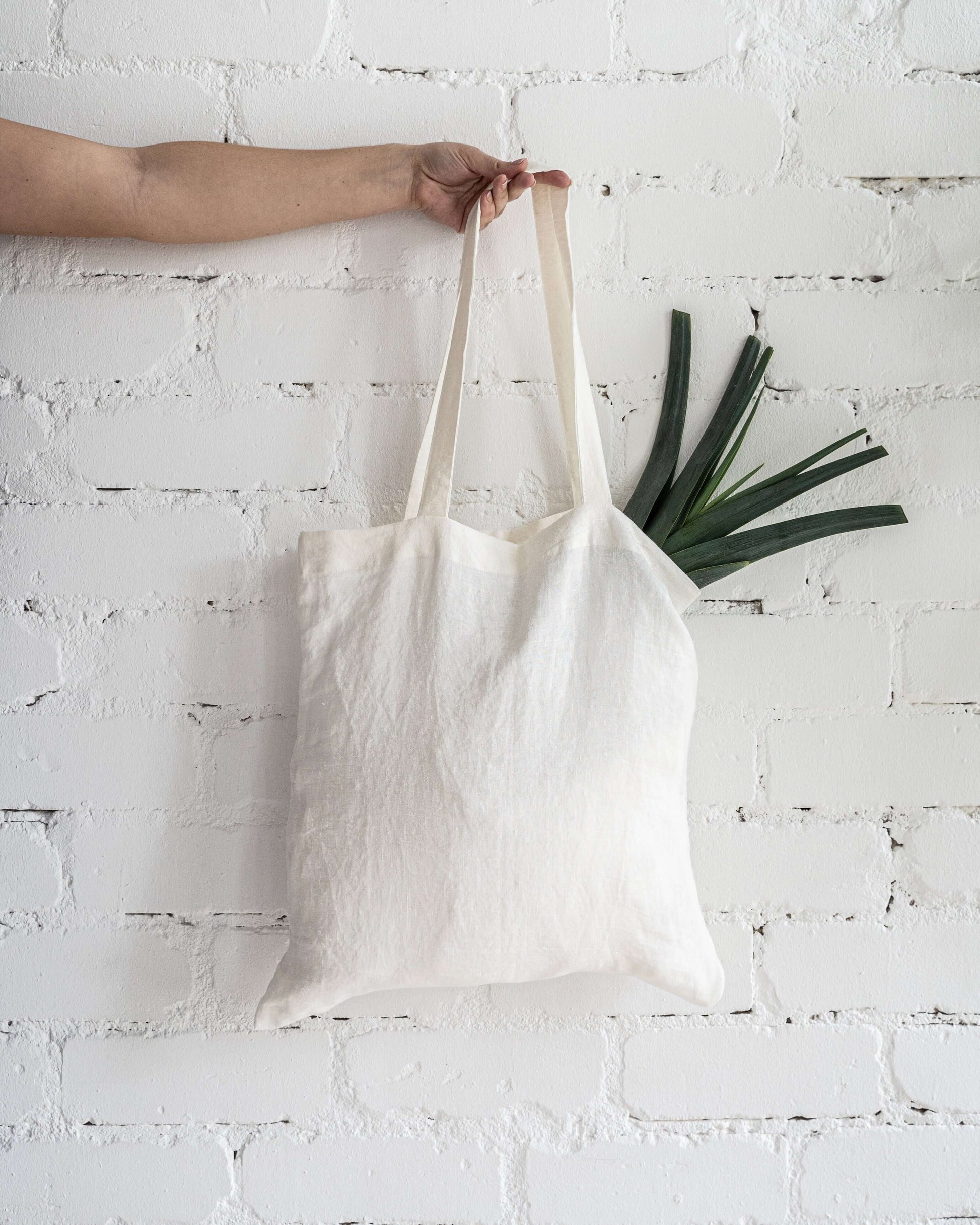 Linen tote bag with small plant, lifestyle styled photo