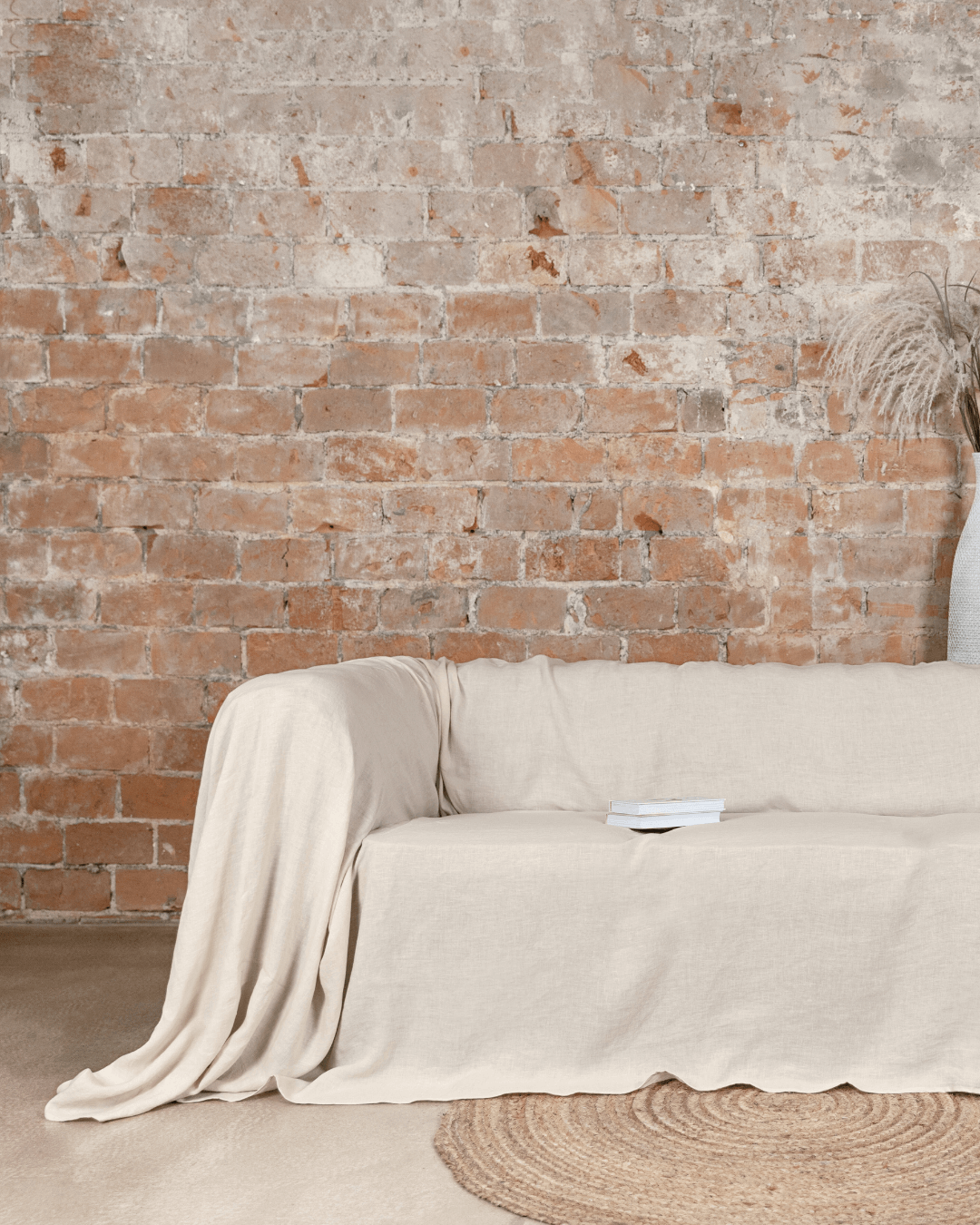Woman sitting on sofa with cream loose linen couch cover