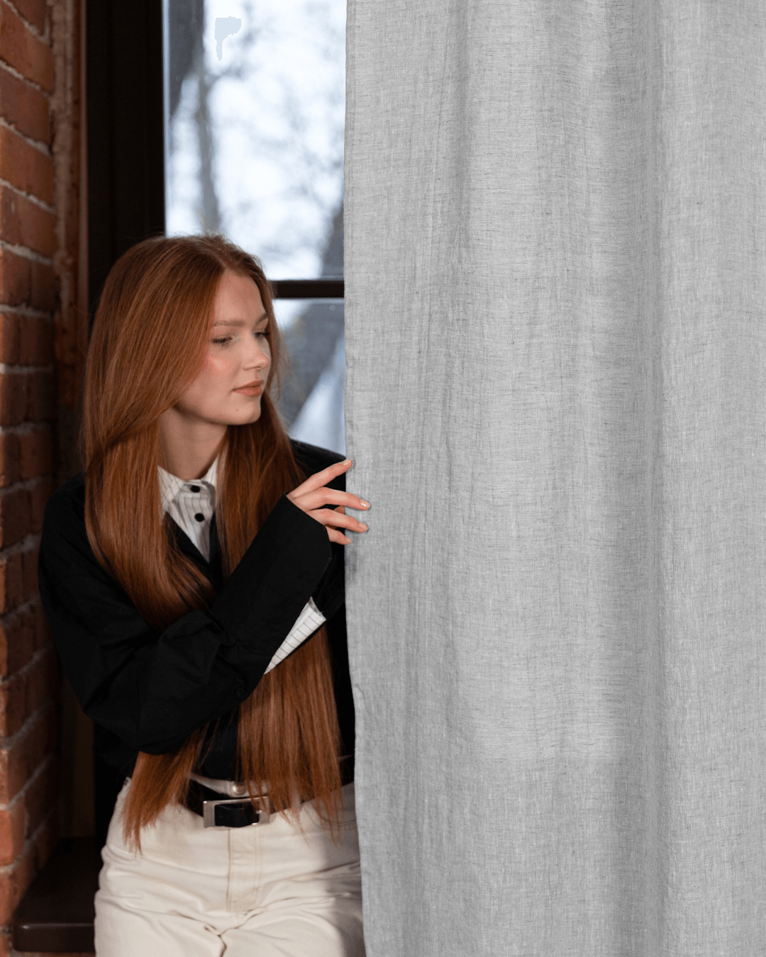 Semi-sheer linen curtain panels melange gray - woman leaning against panel, drape detail