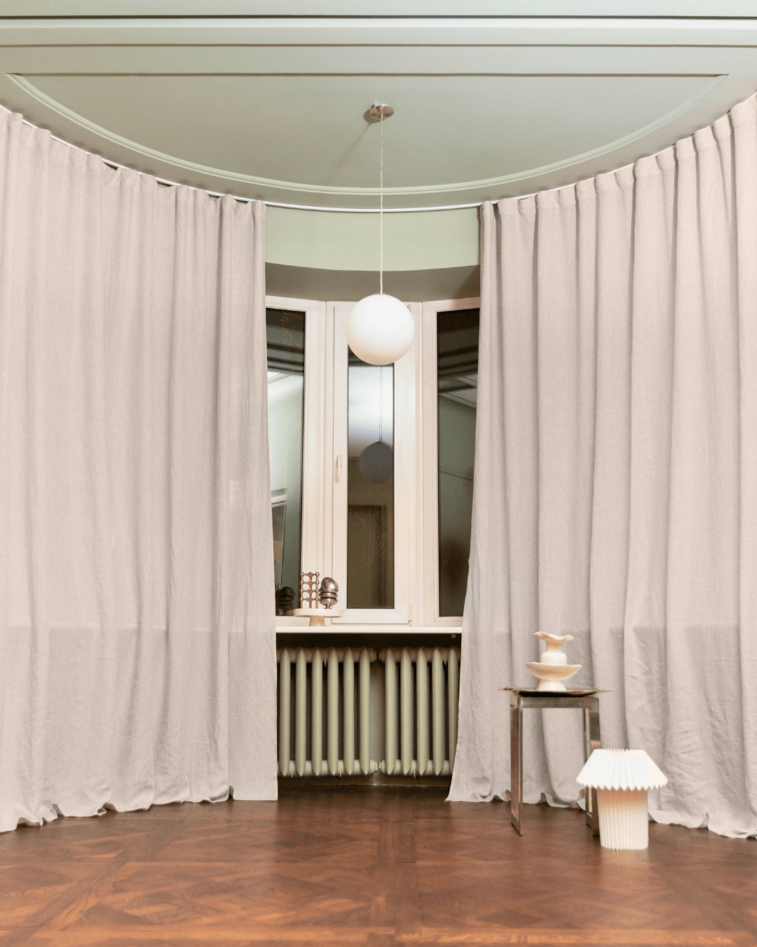 Natural light linen curtains in living room with large window and radiator