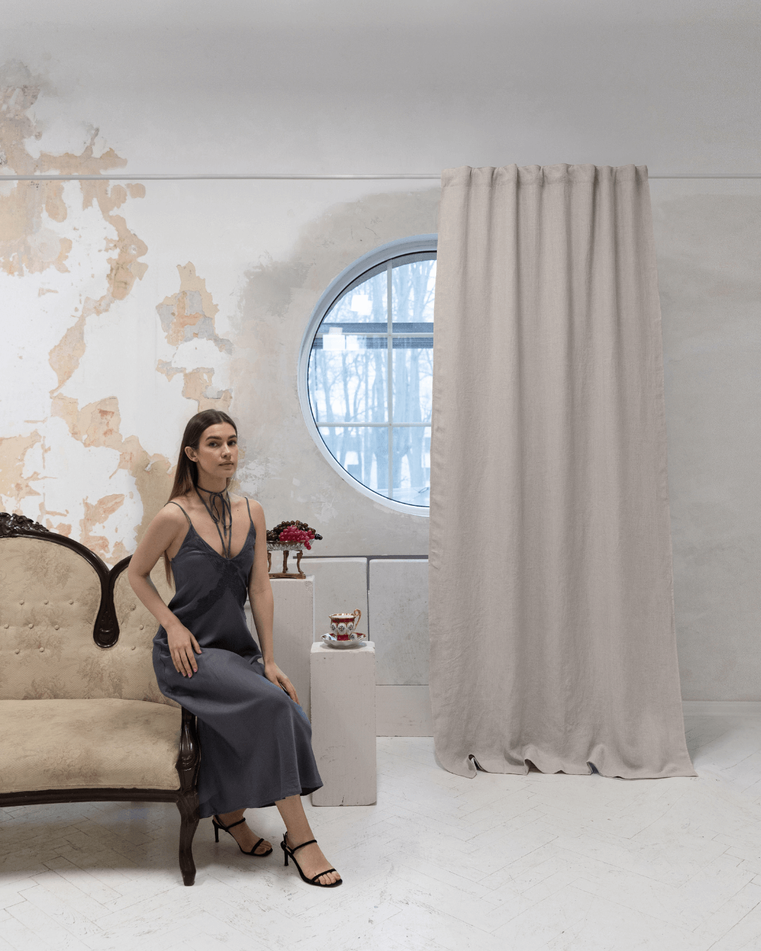 Woman seated by window with natural light linen blackout curtains