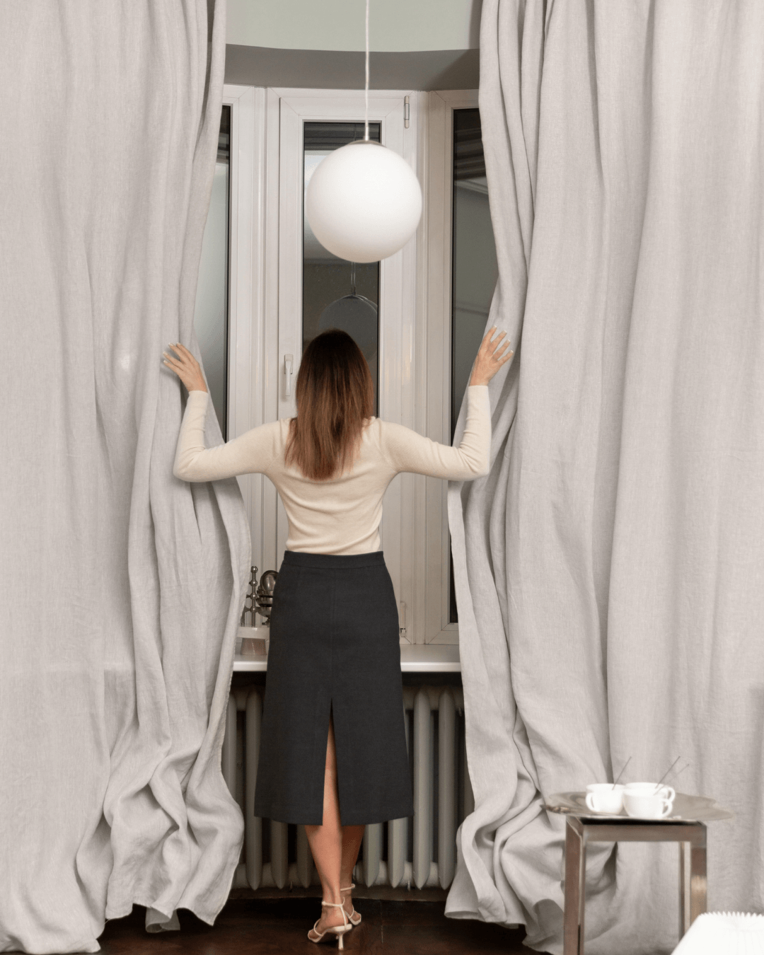 Woman behind natural light linen curtain, showing semi-sheer privacy level
