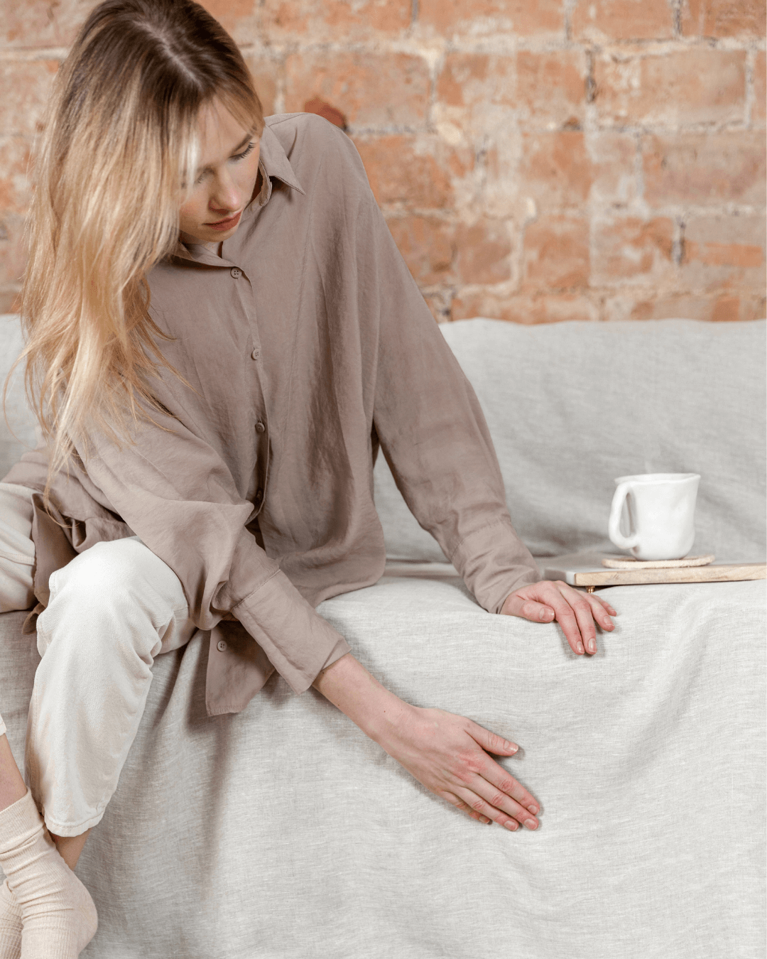 Woman with linen couch cover made from extra wide softened linen fabric