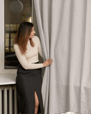 Woman styling natural light semi-sheer linen curtain panels, 175 g/m²
