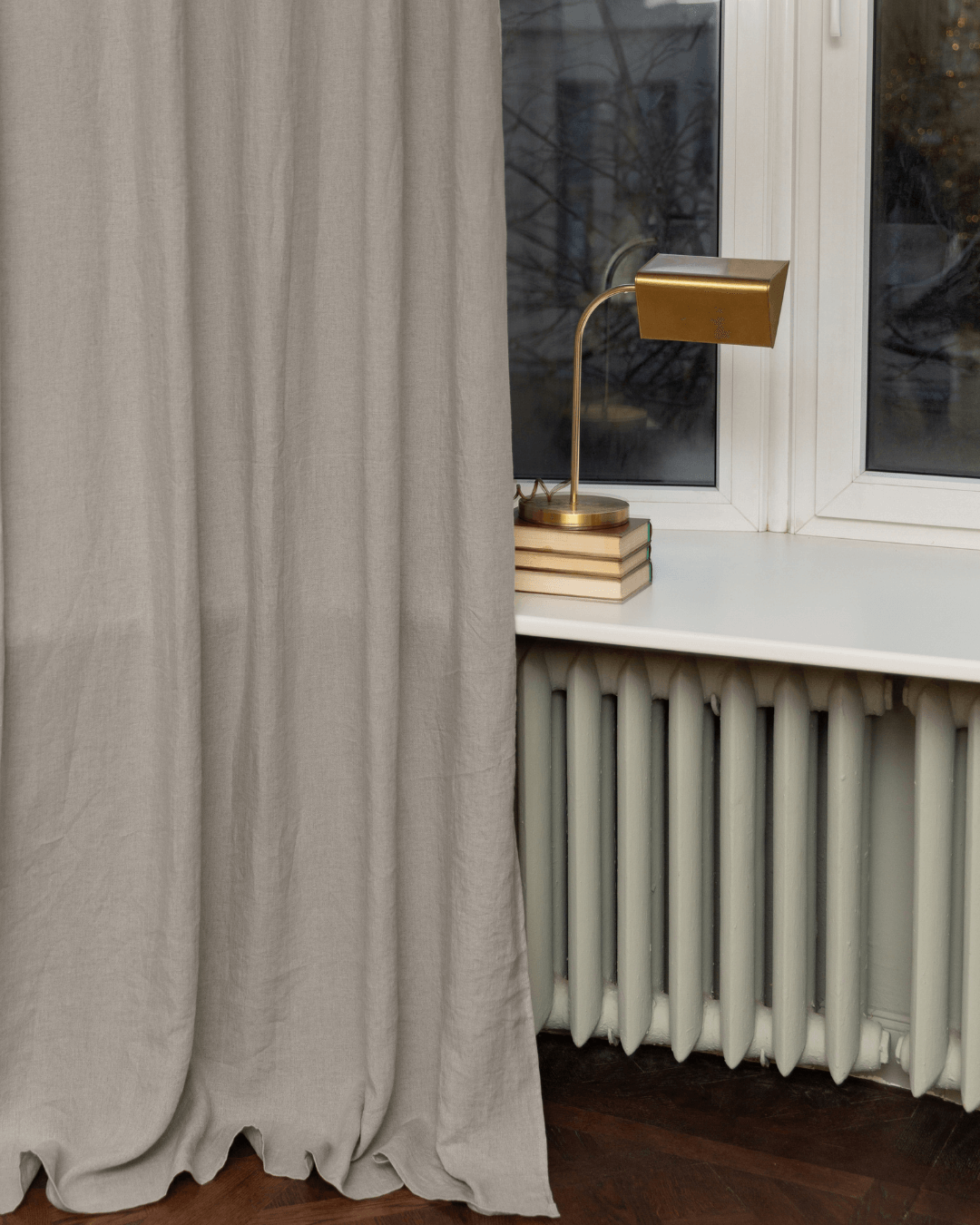Natural linen curtains with table lamp, styled interior detail