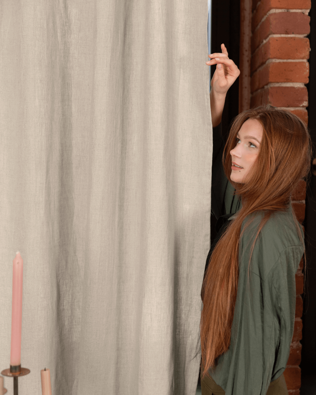Linen curtain panels natural 190 gsm - woman holding candle beside panels