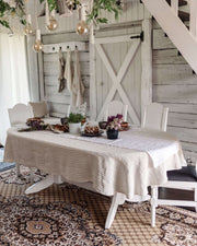 Oval linen tablecloth on dining table, natural tone, top view